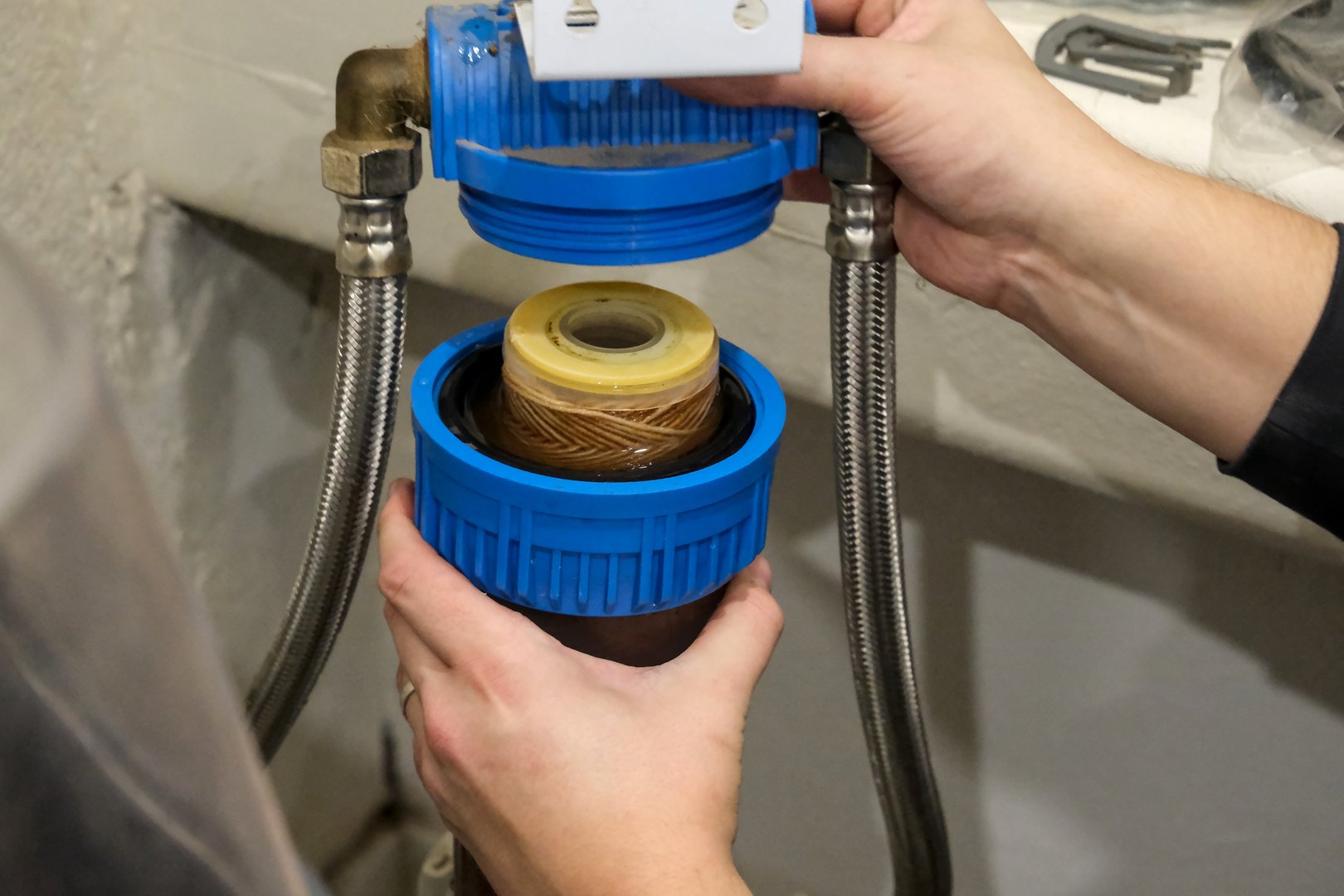 Replacement of a water softener filter cartridge by a technician, in a house.