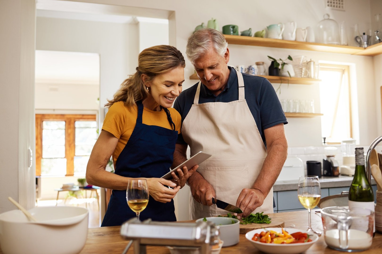 Food, digital tablet and senior couple cooking in kitchen showing healthy meal preparation and partnership in creating sugar-free lifestyle habits