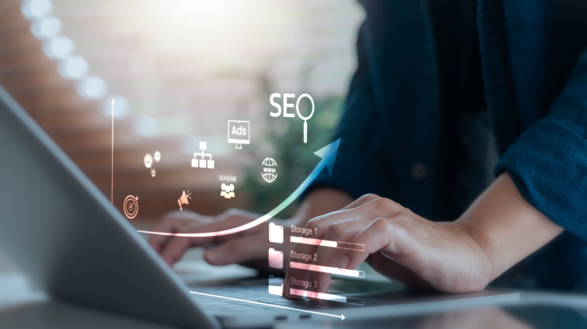 Close-up of hands typing on laptop with SEO icons and upward arrow, representing digital marketing, website optimization, online visibility, and data strategy.