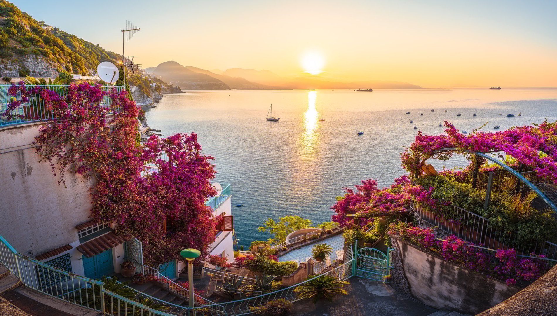 Romantic sunrise on the Amalfi Coast with blooming bougainvillea and sea views.