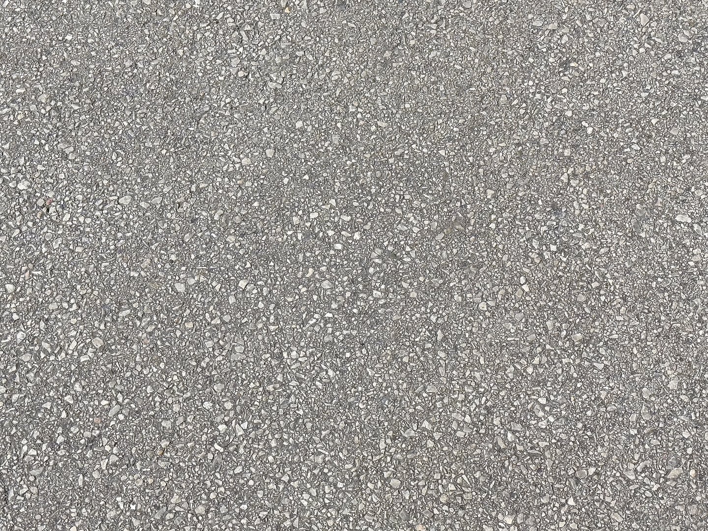 Close-up of textured concrete surface with various pebbles and stones embedded