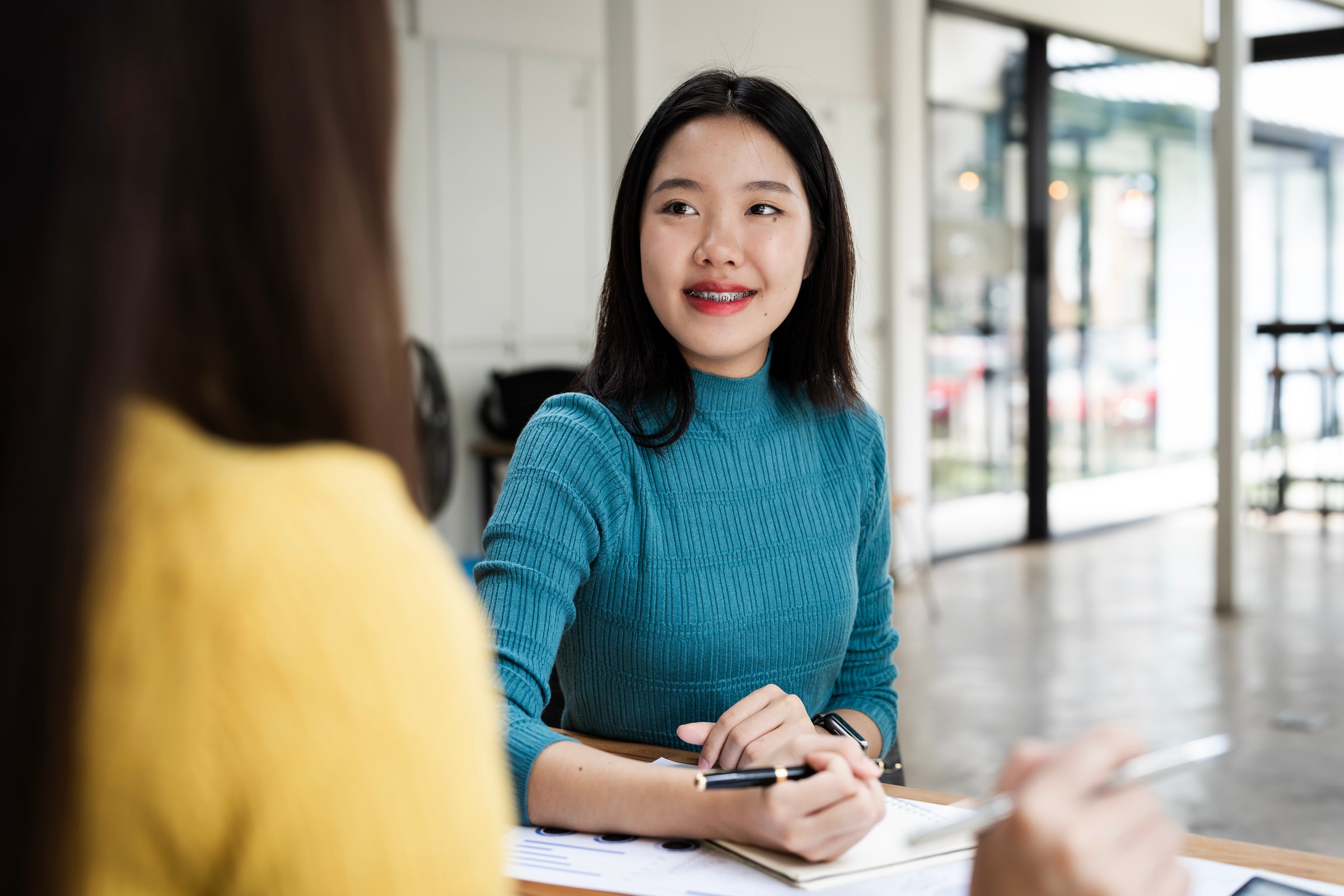 Happy young business woman hr talking to recruit at job interview meeting.