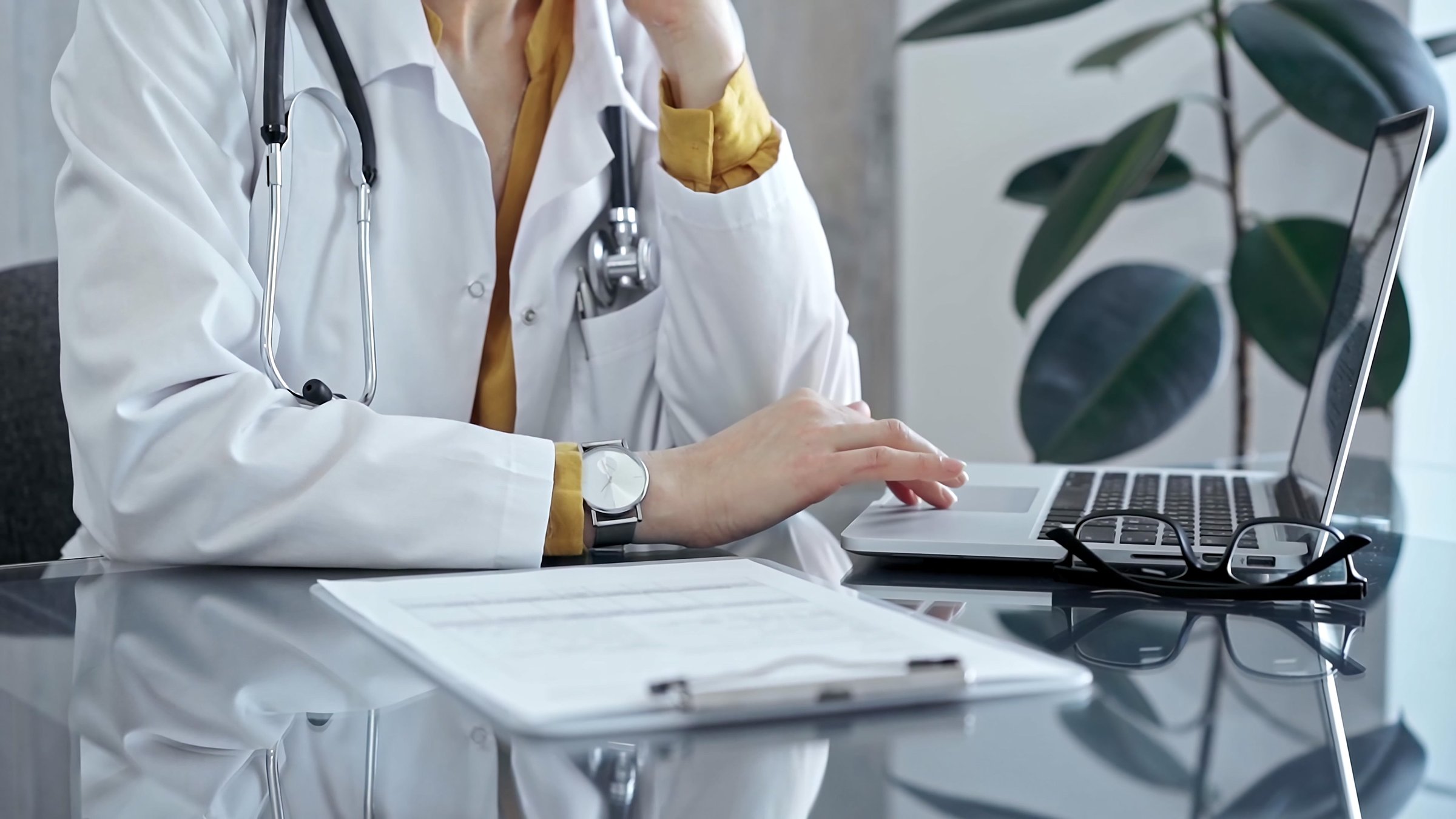 Doctor reviewing medical records on laptop. Close-up of a healthcare professional analyzing patient information on a computer. Medicine and health care