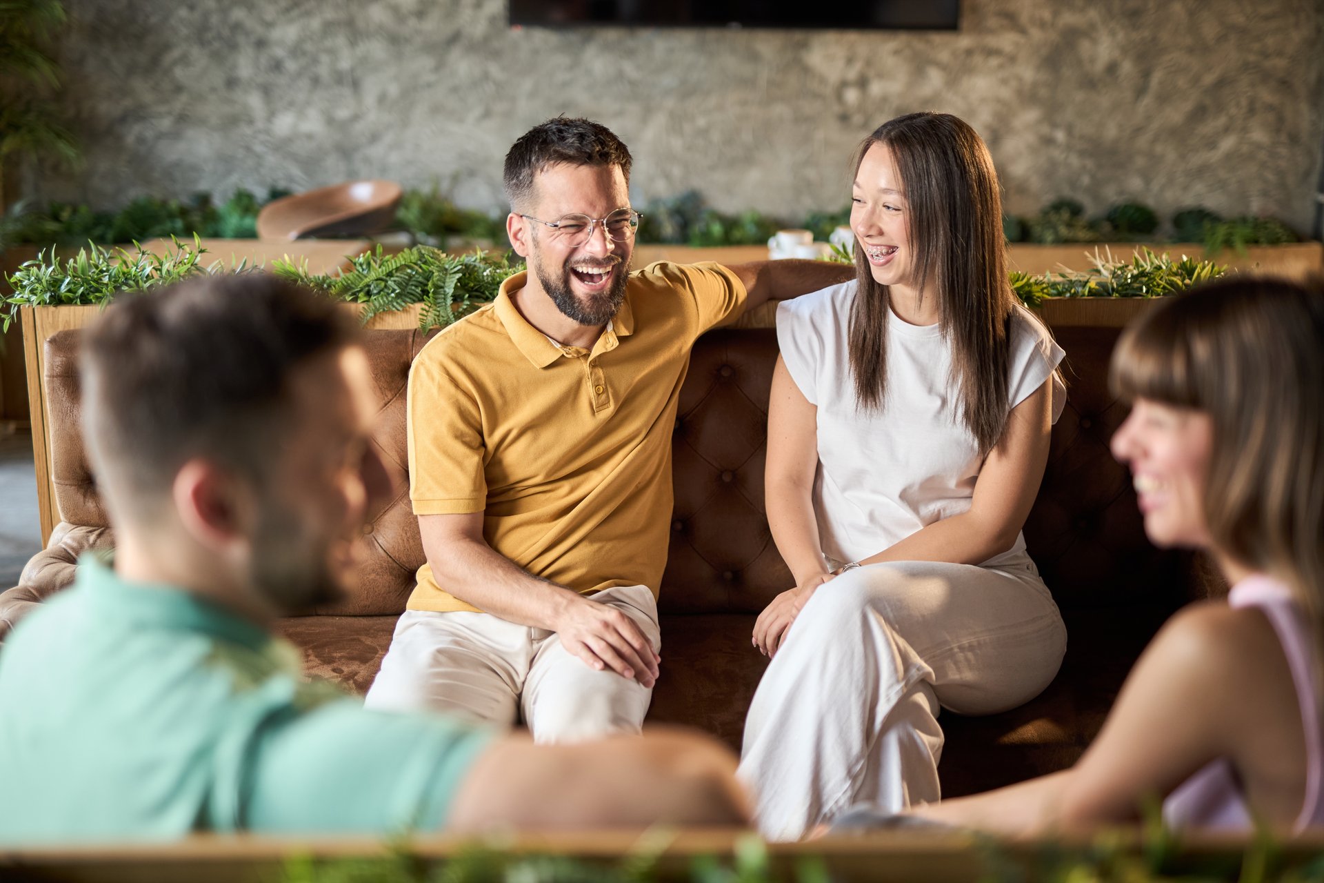 Happy couples enjoying in conversation during a social gathering in a cafe