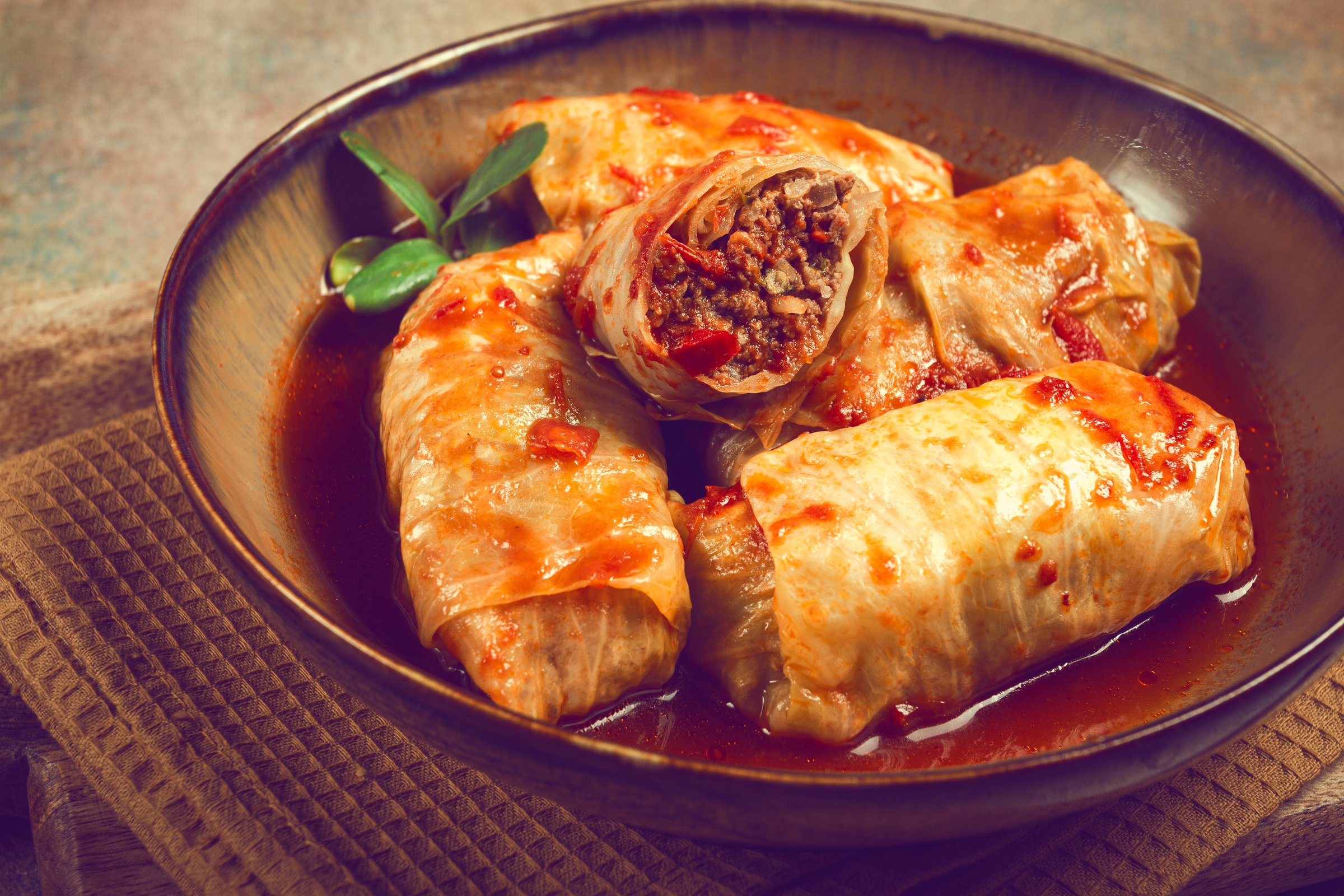 Stuffed cabbage rolls with minced meat, in tomato sauce, top view, without people, in the spotlight.