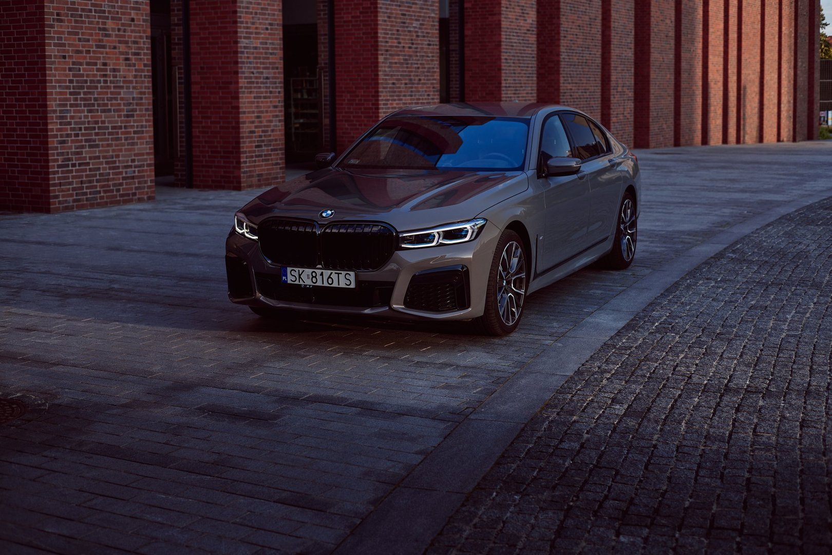 Grey BMW 740D xDrive in front of the NOSPR concert hall. The car is lit by the rays of the setting sun. 340 HP engine, acceleration 0-100 km/h - 5s Katowice, Poland, 12.06.2021