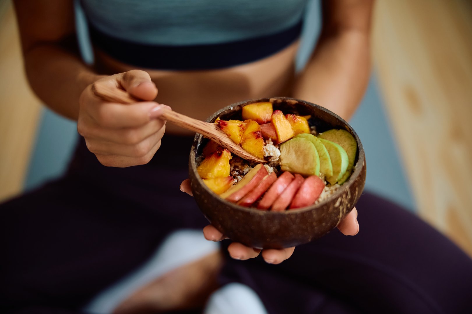 Close up of sportswoman having a healthy snack after exercising.