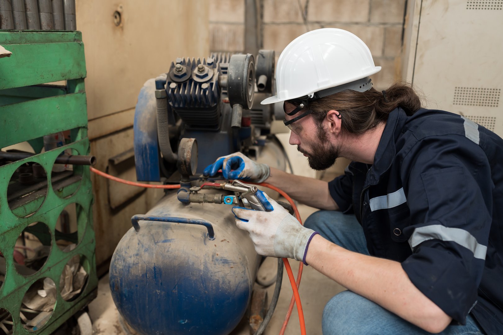 Engineer worker setup, maintain, repair mechanism of operation of air compressor in industry factory. Male engineer worker working with air compressor machine