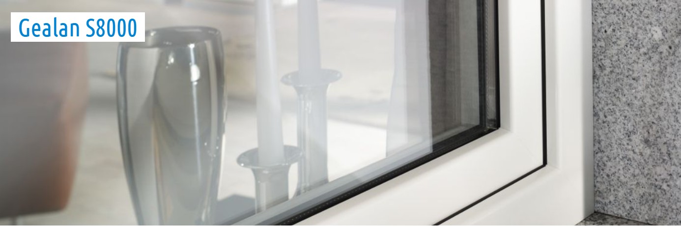 Close-up of a window with the Gealan S8000 frame, featuring a sleek corner and silver candle holders on the sill.