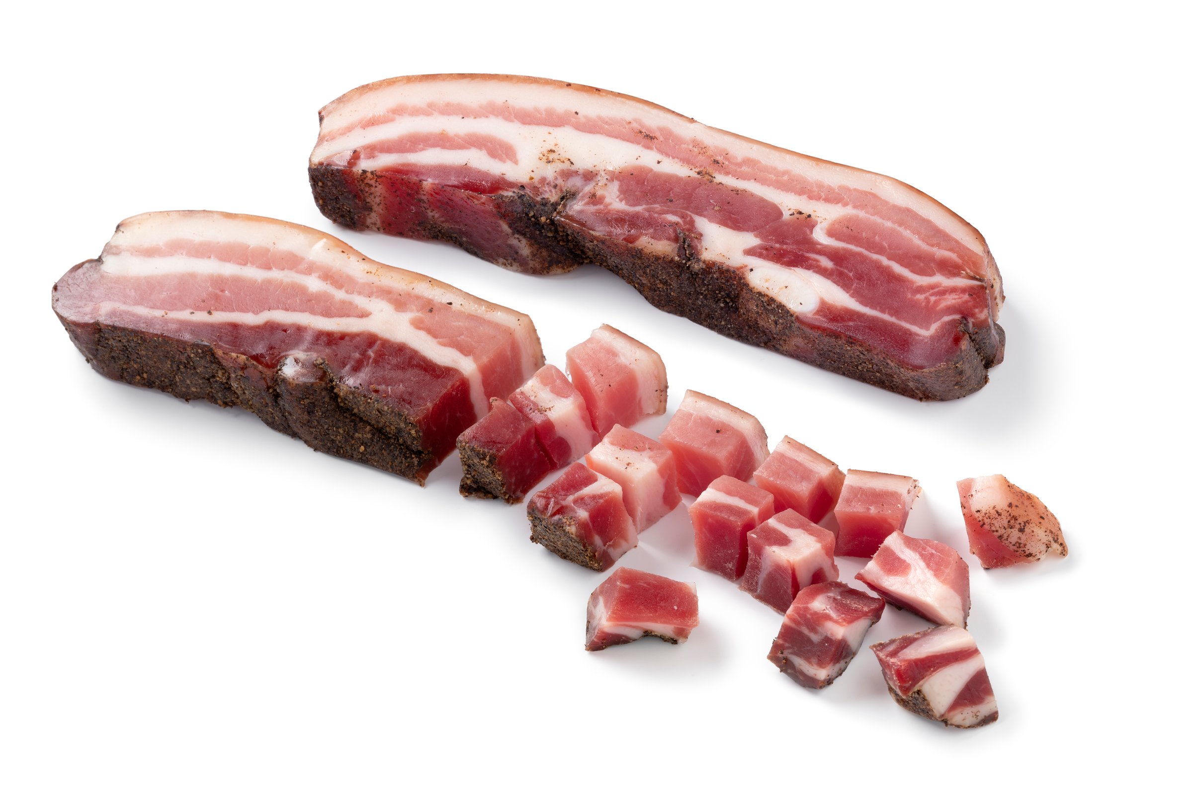 Slice and cubes of Italian pancetta isolated on white background close up