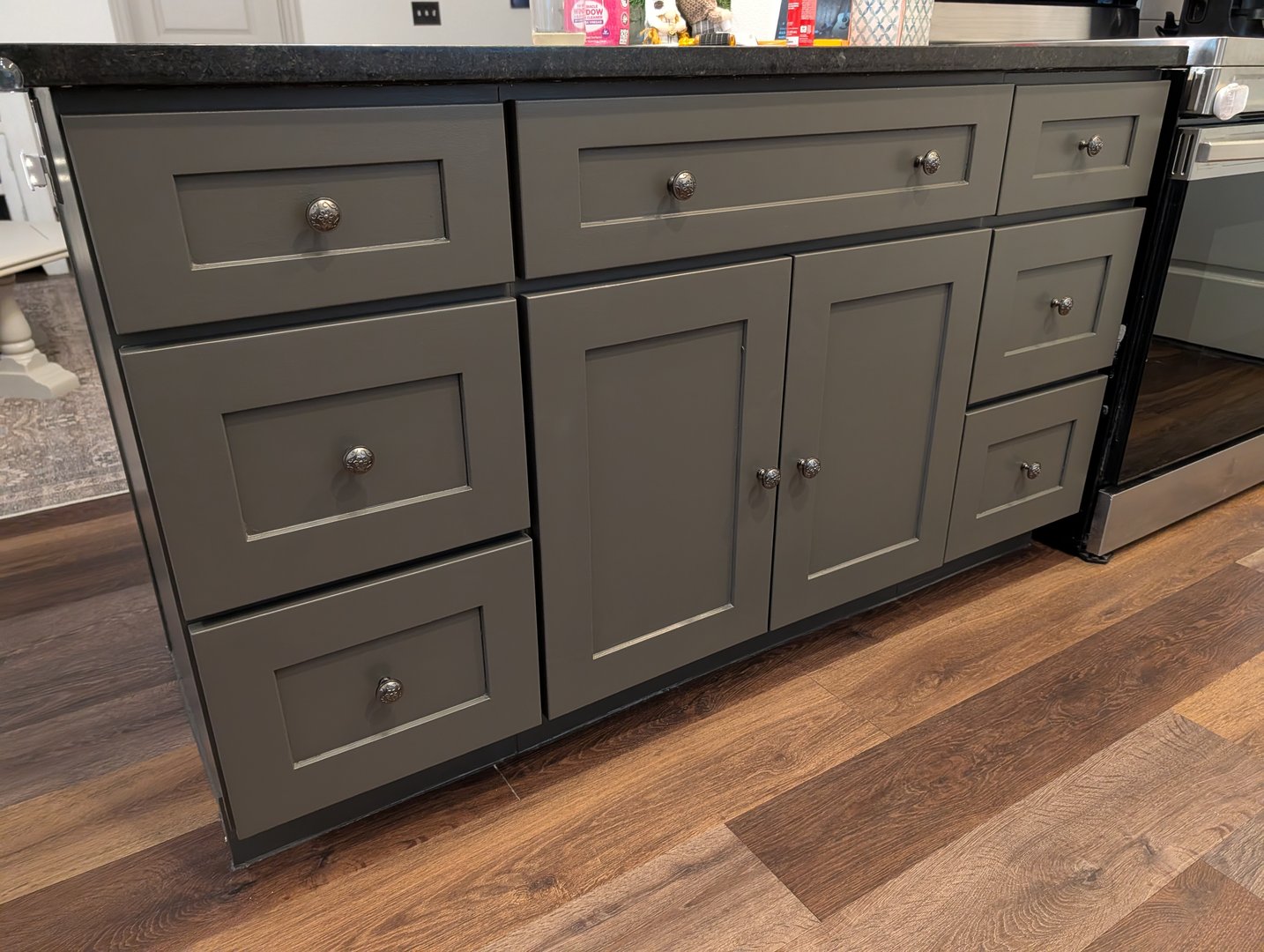 Finished kitchen peninsula with shiplap, Sherwin-Williams Urbane Bronze paint, and custom hardware