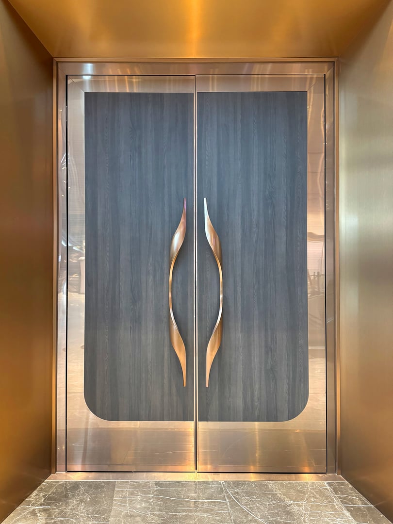 Black wood timber door with curved unique copper door handle