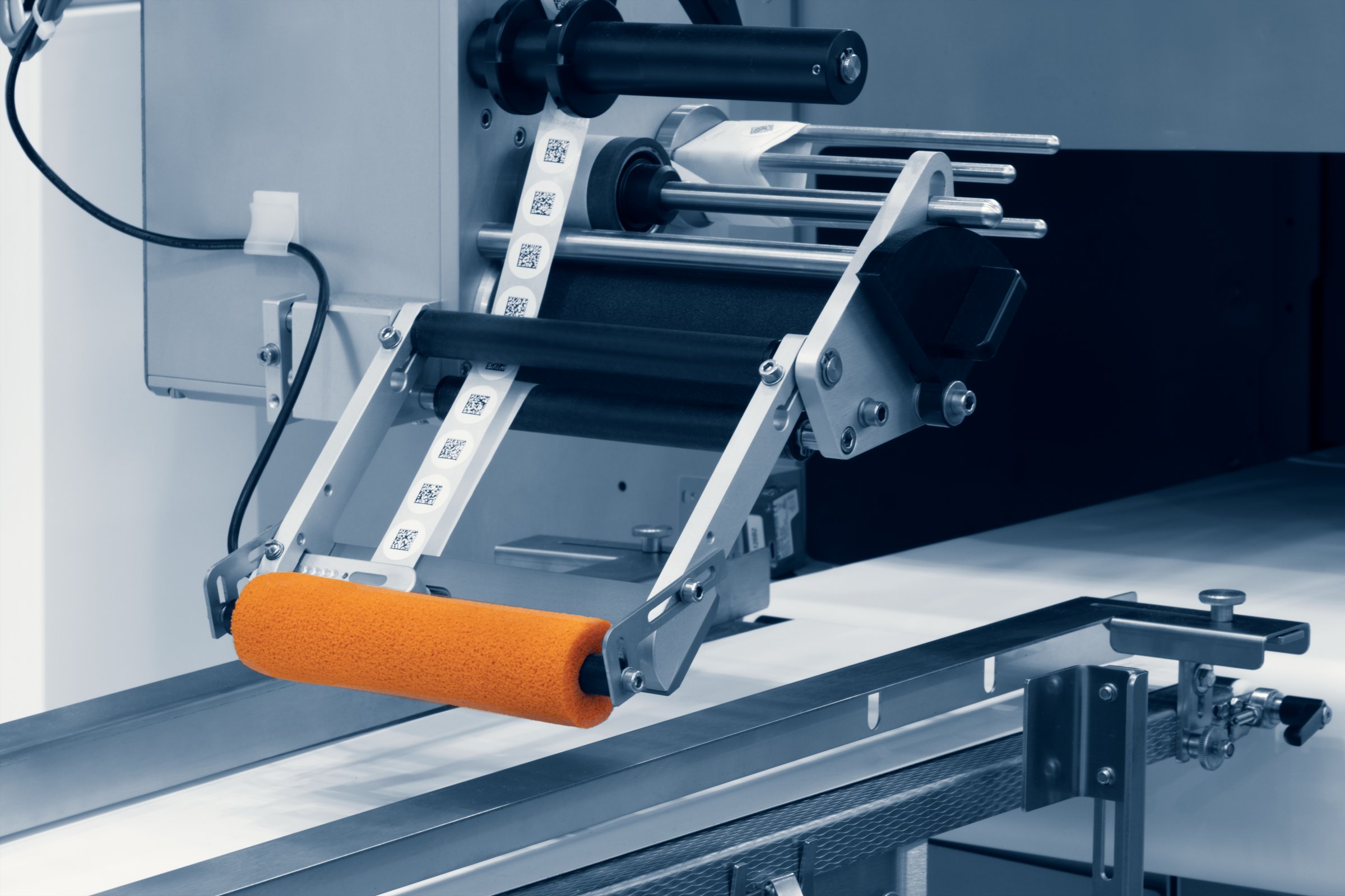 Fragment of the conveyor of sticking labeling QR code machine. Abstract industrial background.