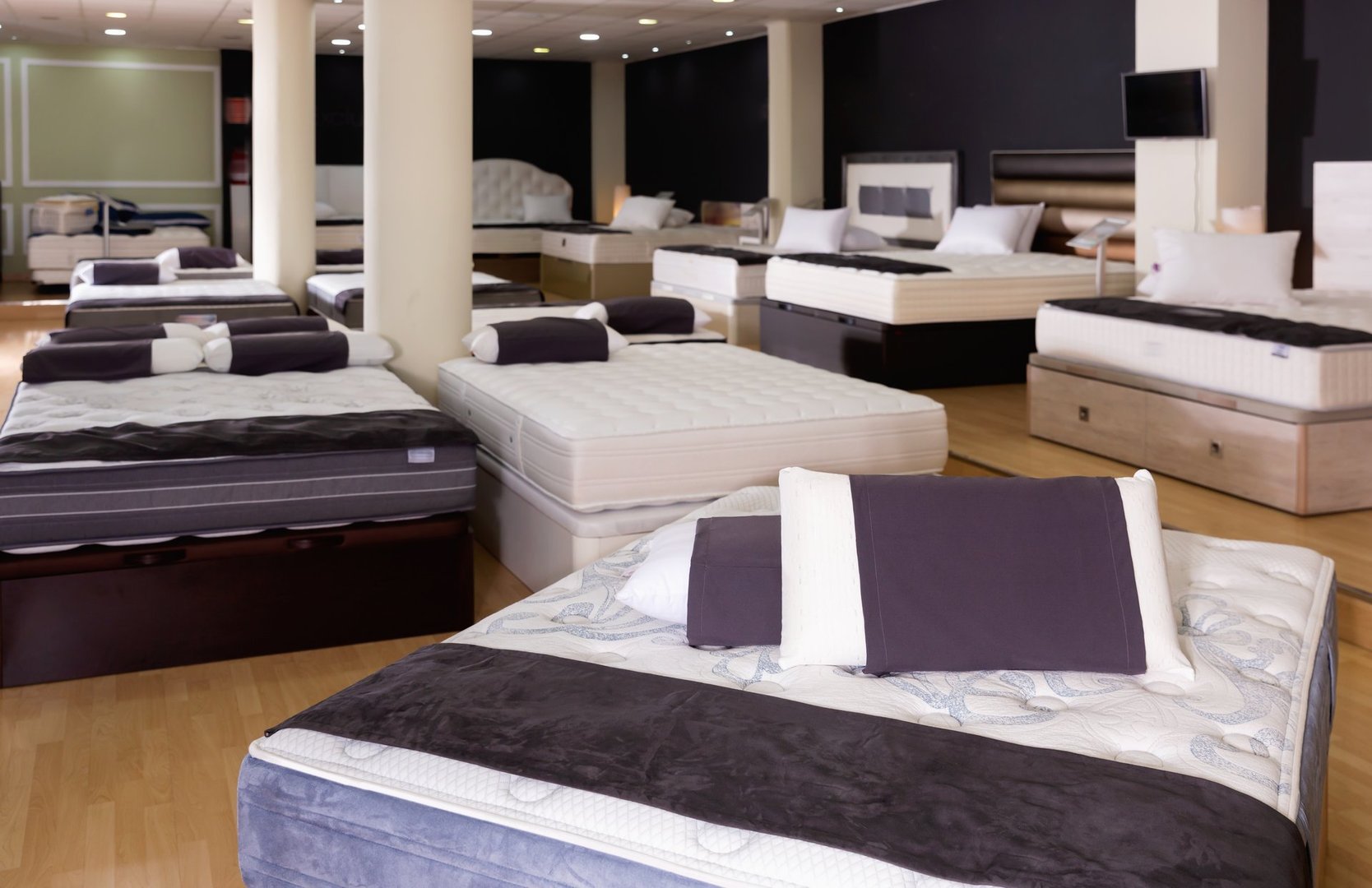 Closeup of pillows on modern   stylish fashionable orthopedic mattress on display for sale in furniture store, with copyspace