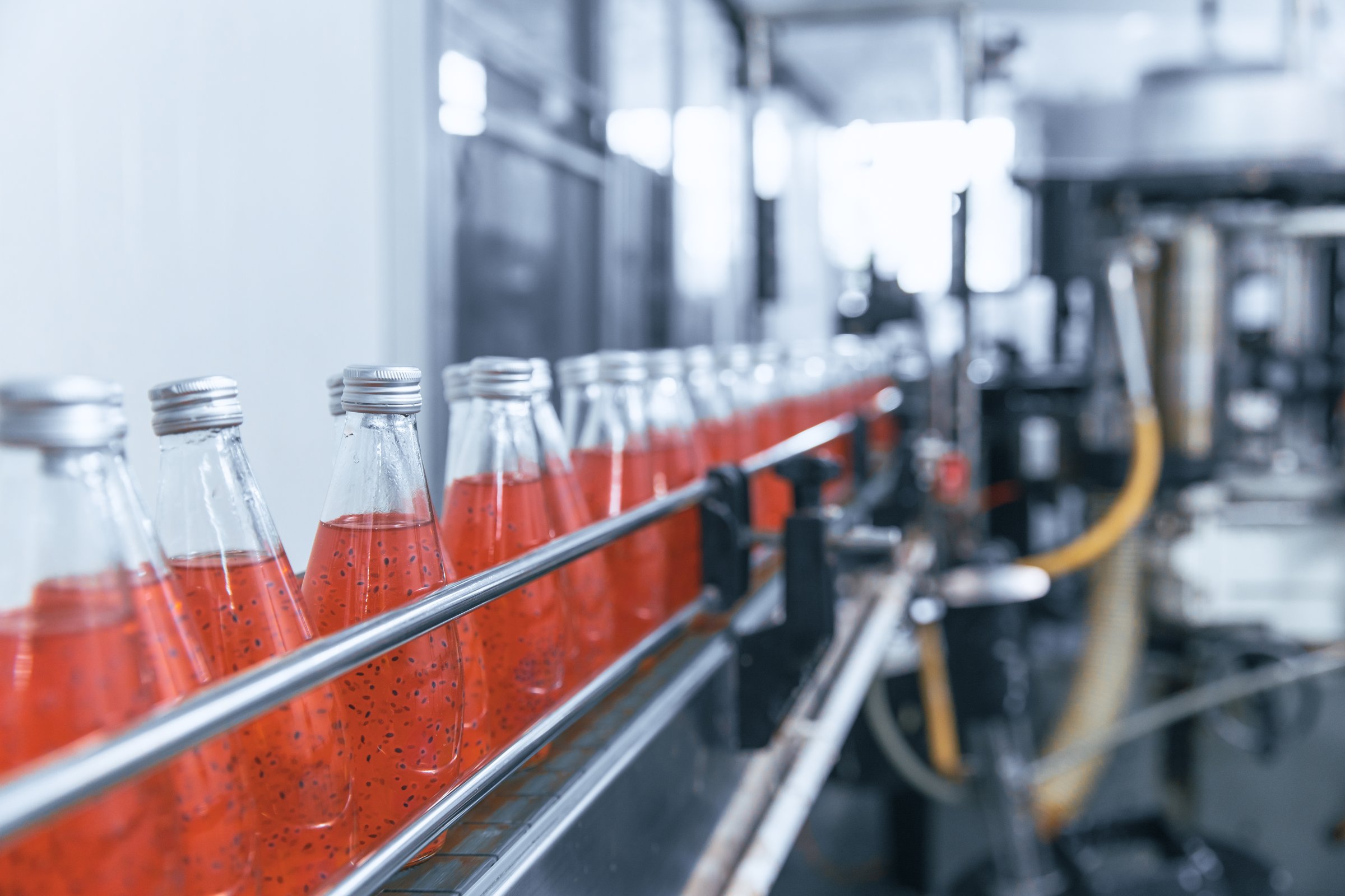 Closeup automation beverage bottled in drink factory automatic working process production line conveyor belt in Industry 4.0 standard.