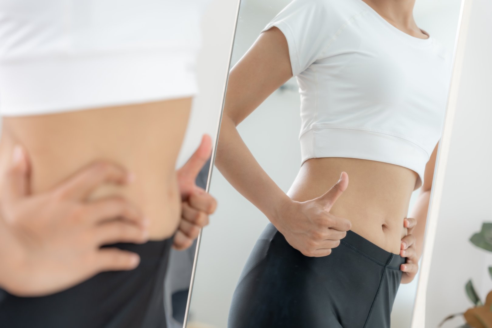 Women showing results of diet. Beautiful shape. female look mirror for check shape body have a reduced waist size after under going a weight loss corse. balance, control, routines, exercise.