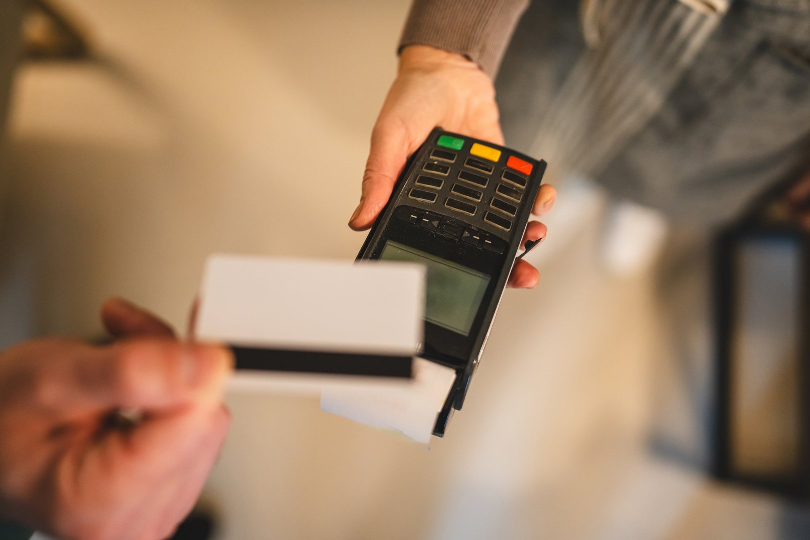 A close-up view of a person using a credit card terminal for payment, showcasing modern technology in financial transactions, conveying efficiency and convenience