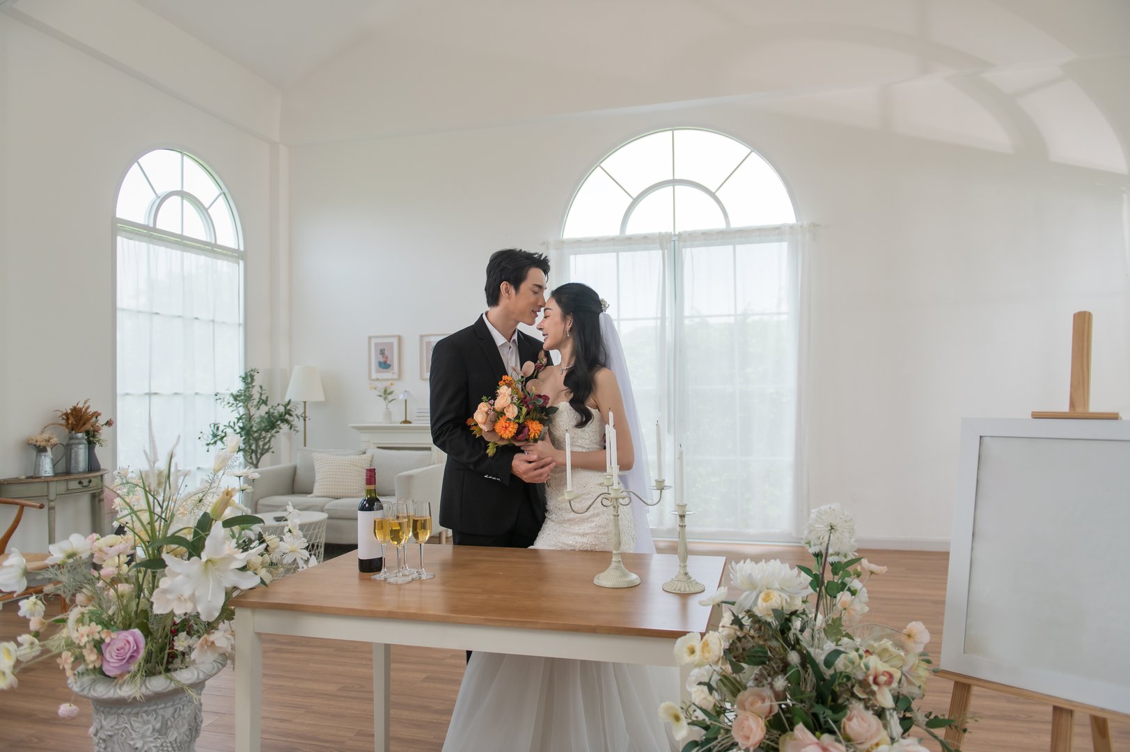 Romantic moment of an Asian bride and groom standing together and smiling during their wedding ceremony