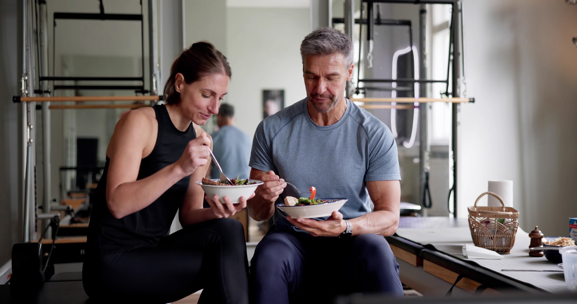 Eating Healthy Food Salad In Gym. Fit Athlete Couple - High Performance Nutrition Guide at SugarFree.Space