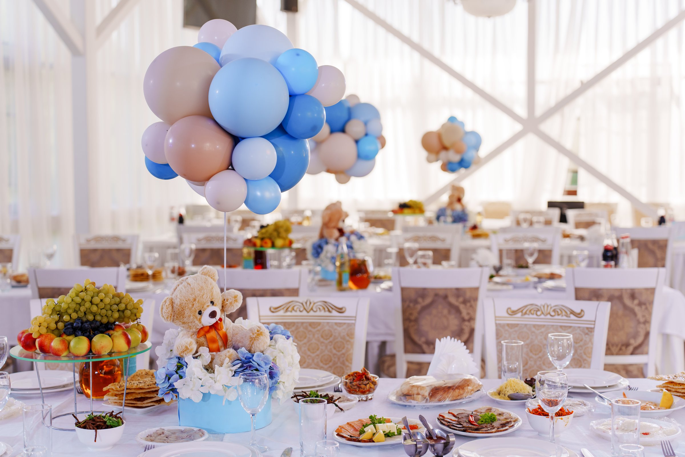 Setting and decorating tables for a children's party in the banquet hall. Balloons and teddy bears at a birthday party in a restaurant.
