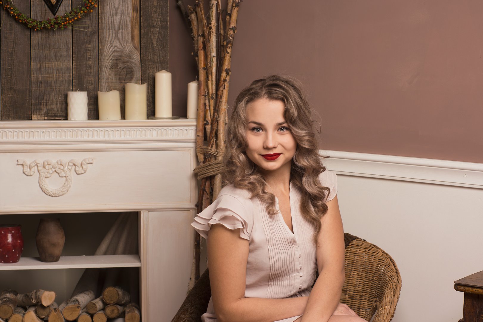 beautiful girl sitting in a chair by the fireplace