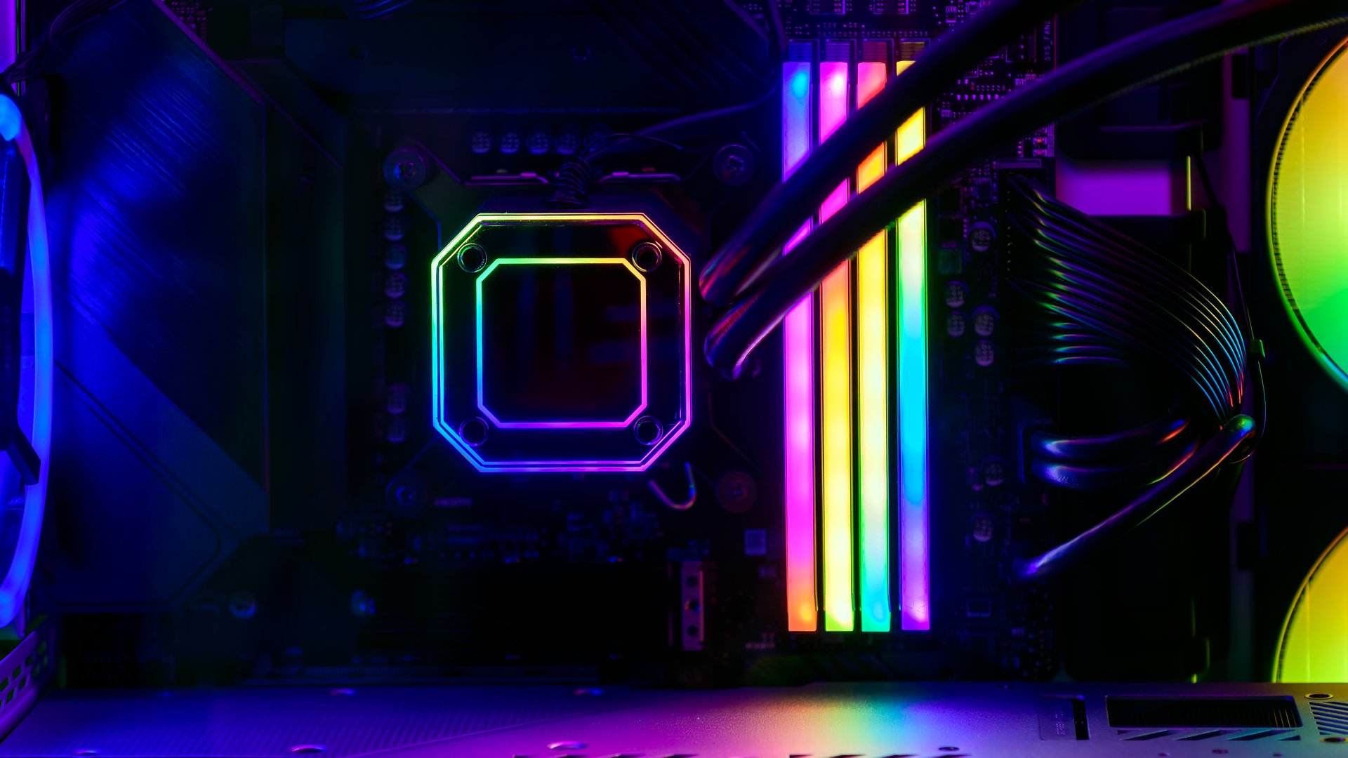 Close-up view of modern gaming PC in glass case with RGB glowing RAM, CPU water cooling