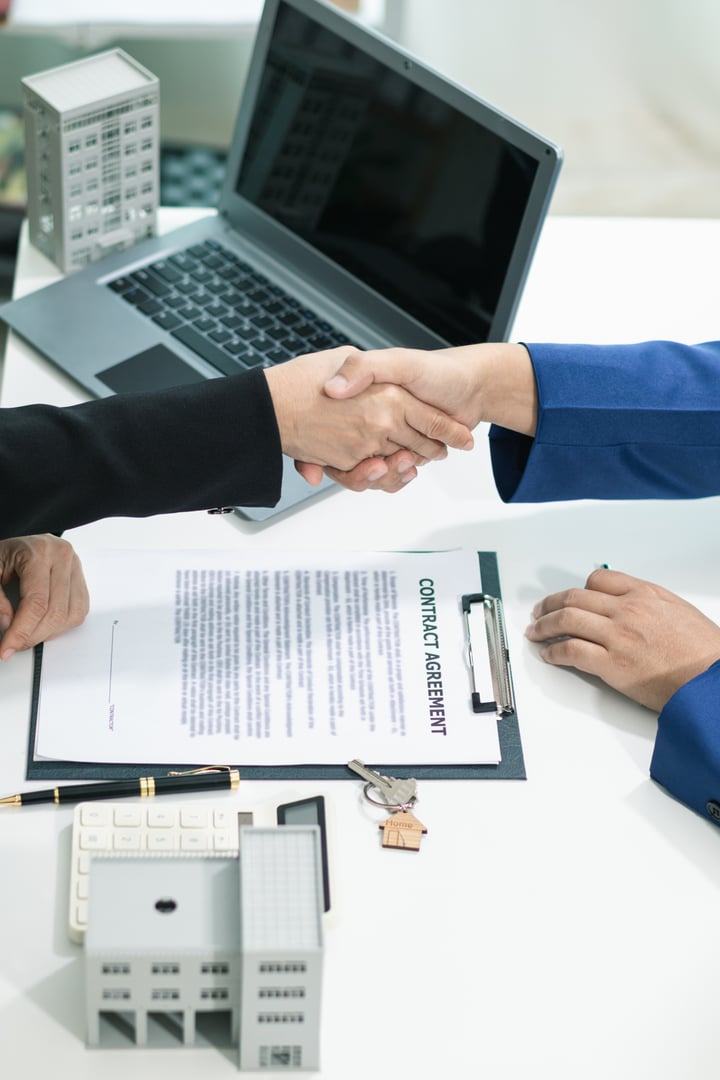 real estate agent shakes hands with customer after agreeing to sign sales contract and signing contract deliver real estate customer. concept of success in agreeing to sign real estate sales contract