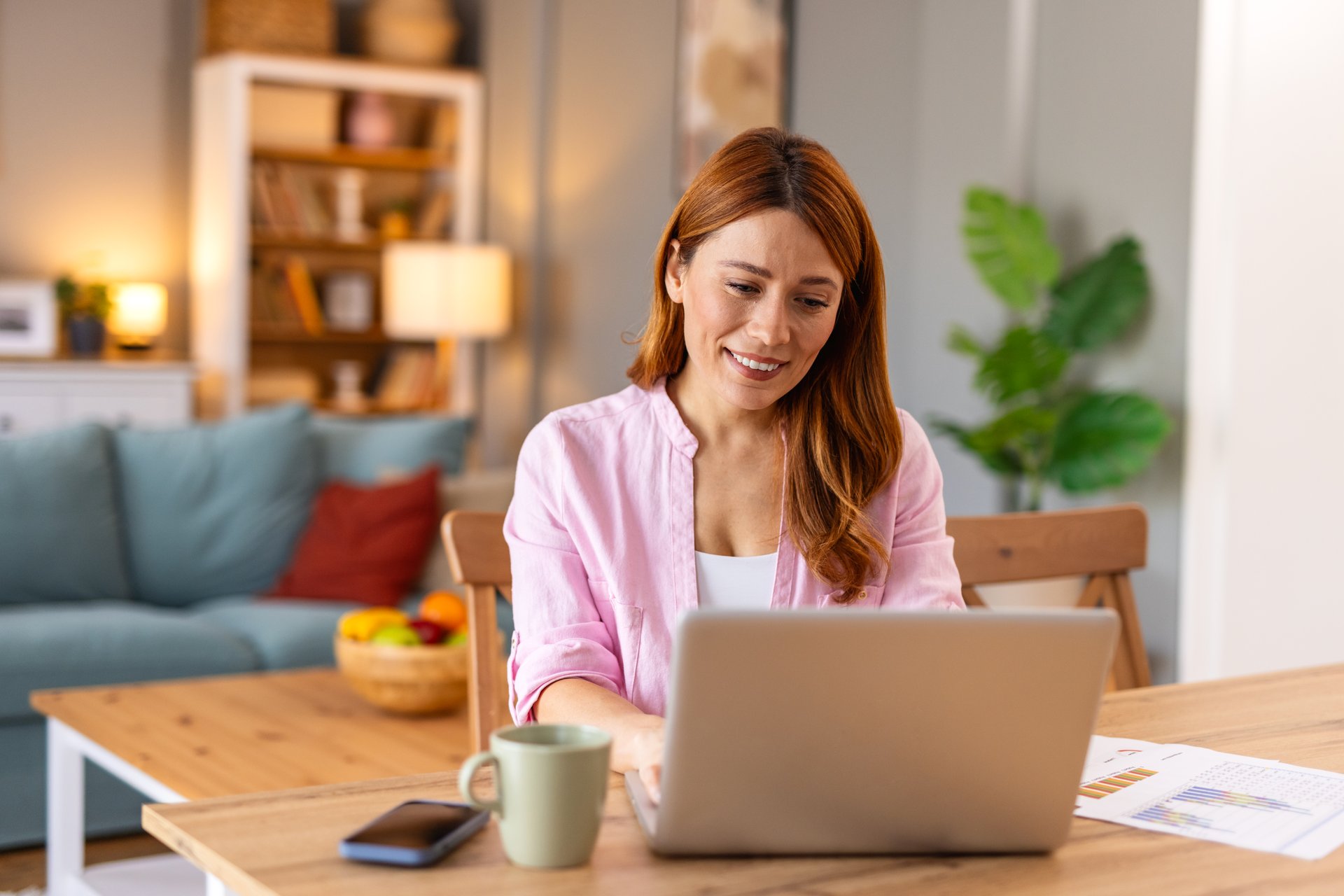 Woman following bed bug heater setup guide on laptop, with heating equipment nearby
