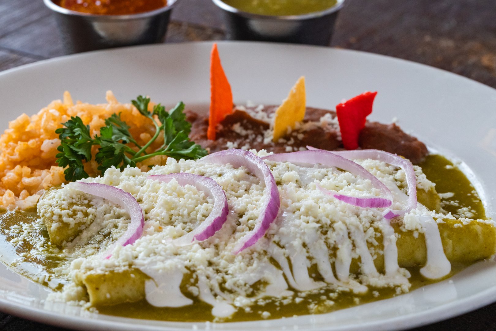 Enchilada topped with melted cheese on a white plate