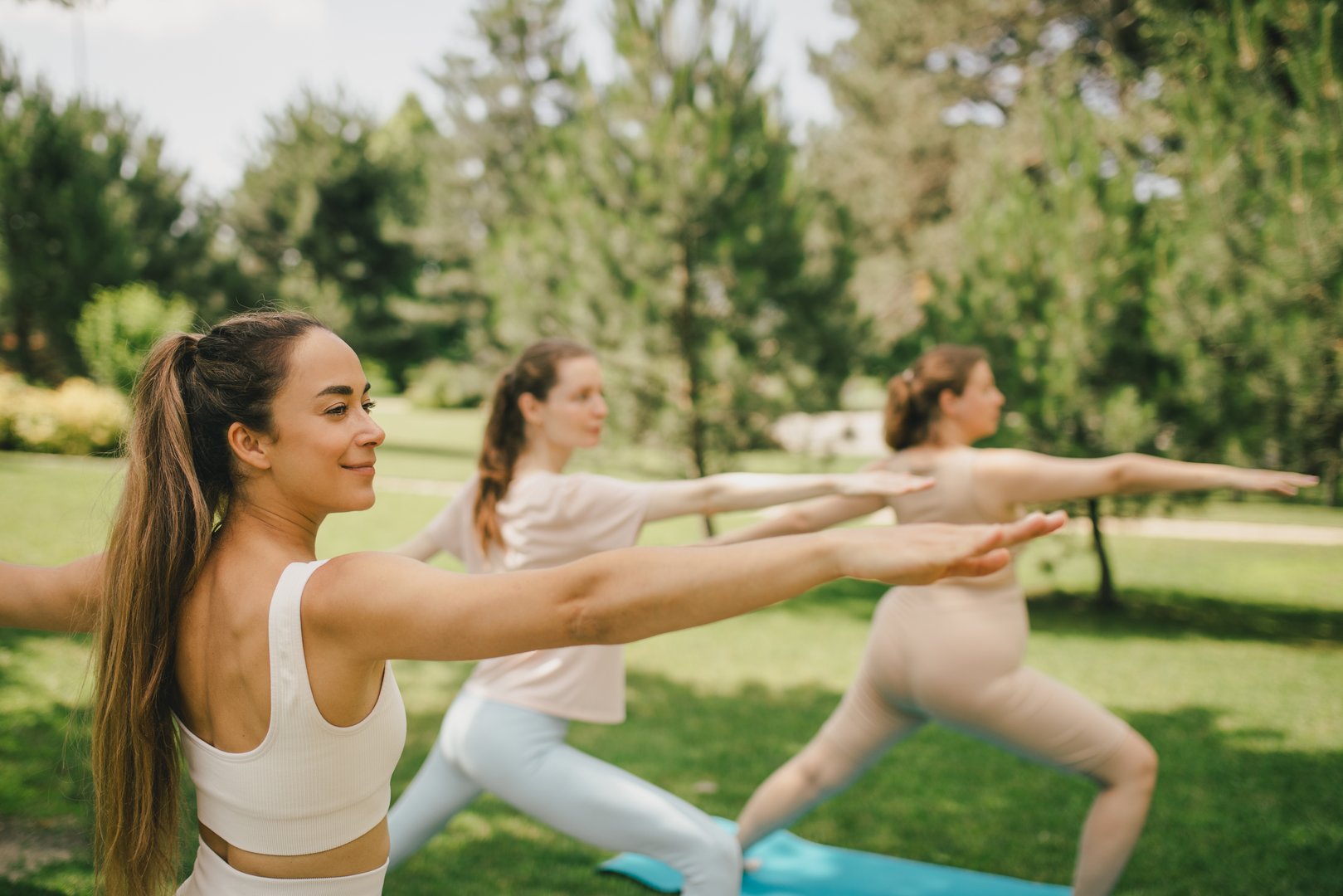 Group of diverse millennial women having group yoga class in a park. Healthy lifestyle.
