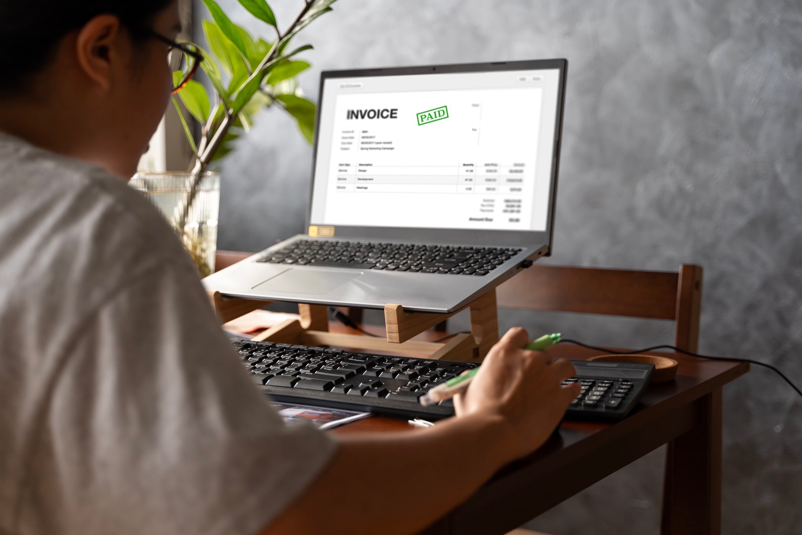Accountant Using E Invoice Software At Computer In Office. Online digital e-invoicing and statement software. Financial accounting concepts, online taxes and billing, electronic management invoices.