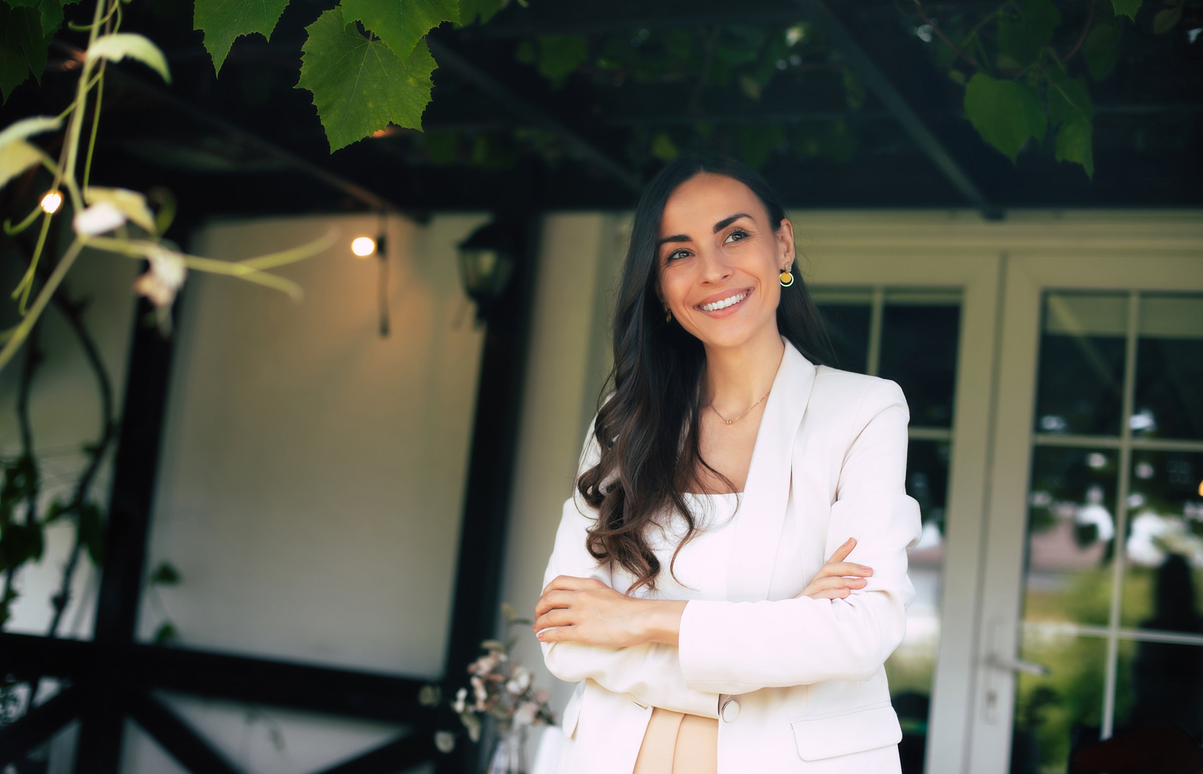 Close Up portrait of smiling satisfied gorgeous modern business woman in formal wear with crossed arms looking away and staying outdoors
