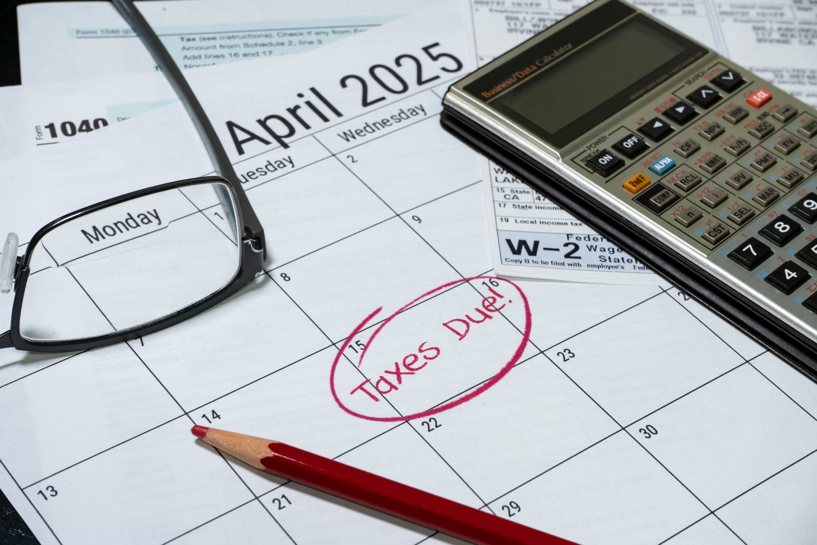 2024 US taxes due calendar reminder with tax forms calculator and glasses.