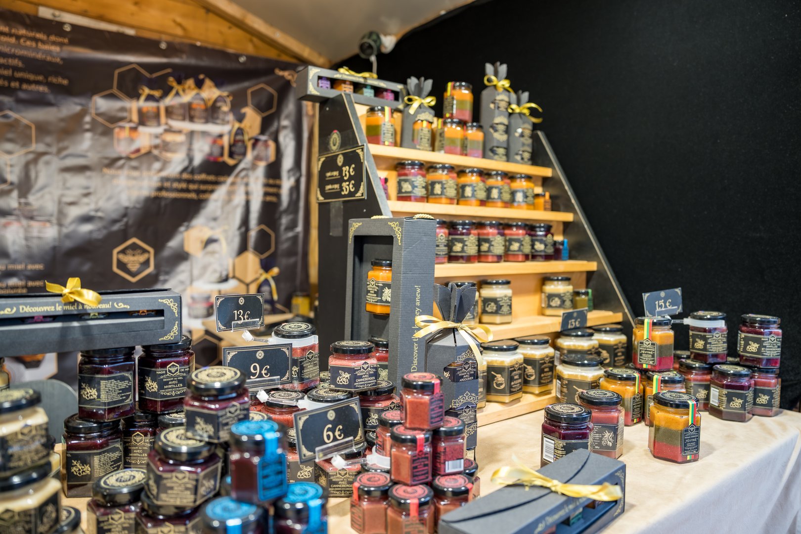 Puteaux,France-14.12.2024 Colorful jars of homemade jams and preserves are artistically arranged on a wooden stall, inviting visitors to savor these delicious fall flavors at the market.