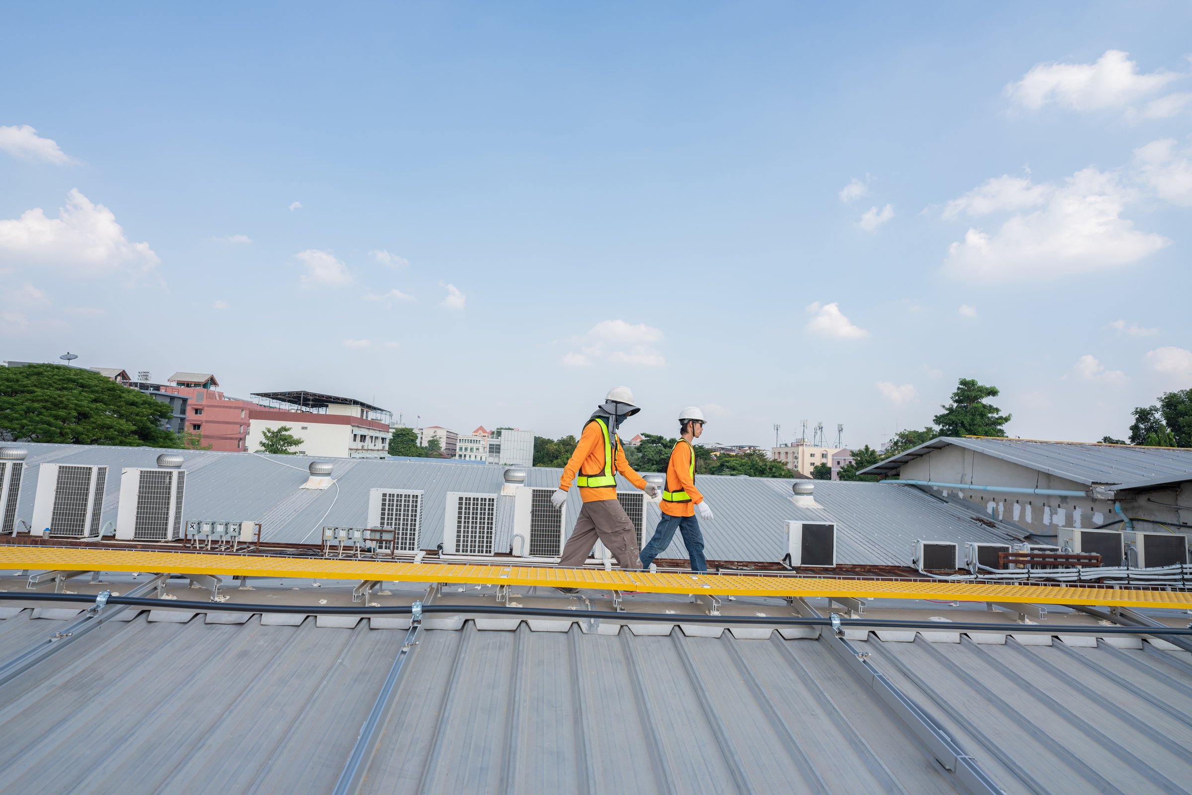 Men technicians carrying photovoltaic solar moduls on roof of factory on the morning. Installing a Solar Cell on a Roof. Solar panels on roof. Workers installing solar cell power plant eco technology.