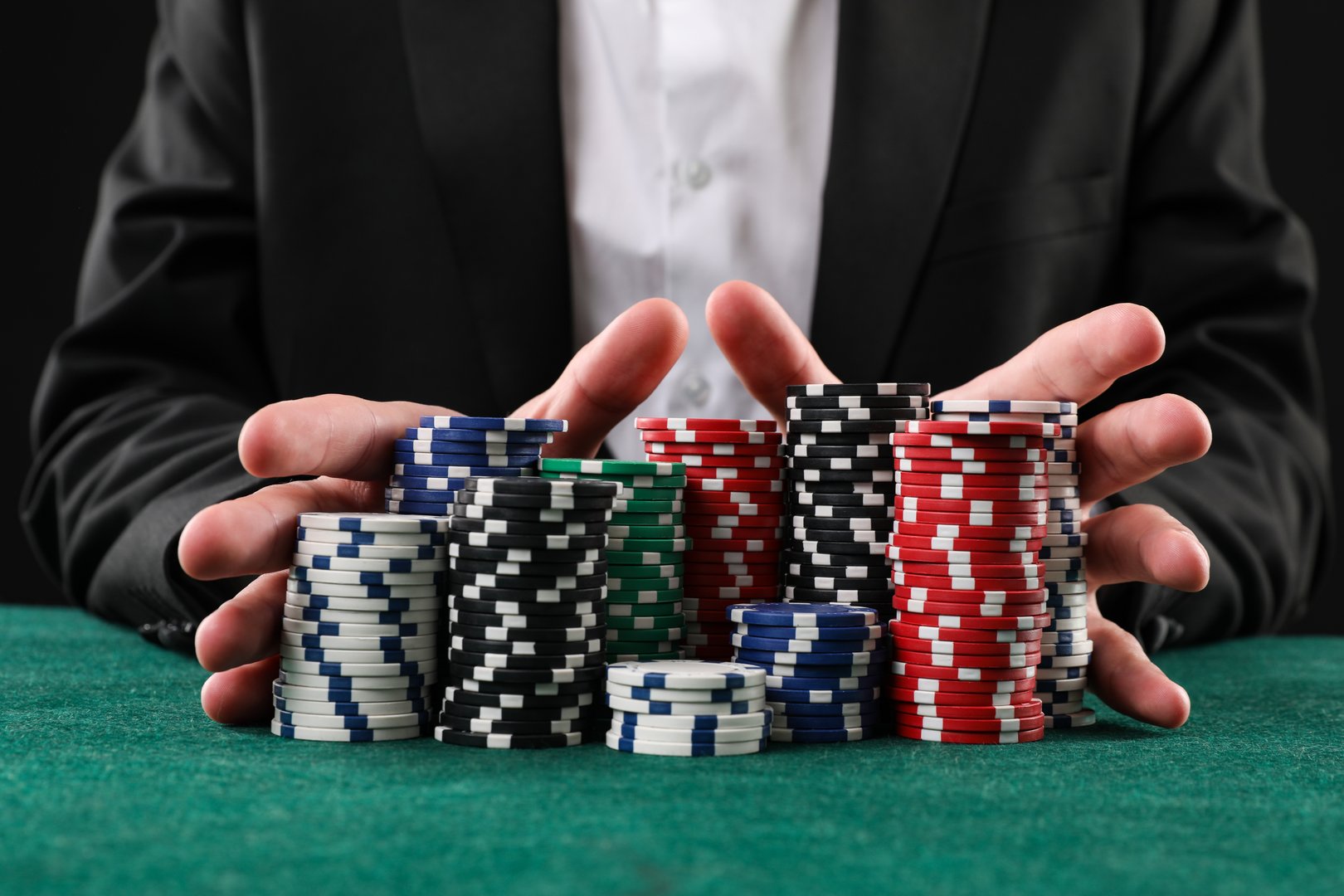 Man with casino chips playing poker at gambling table, closeup