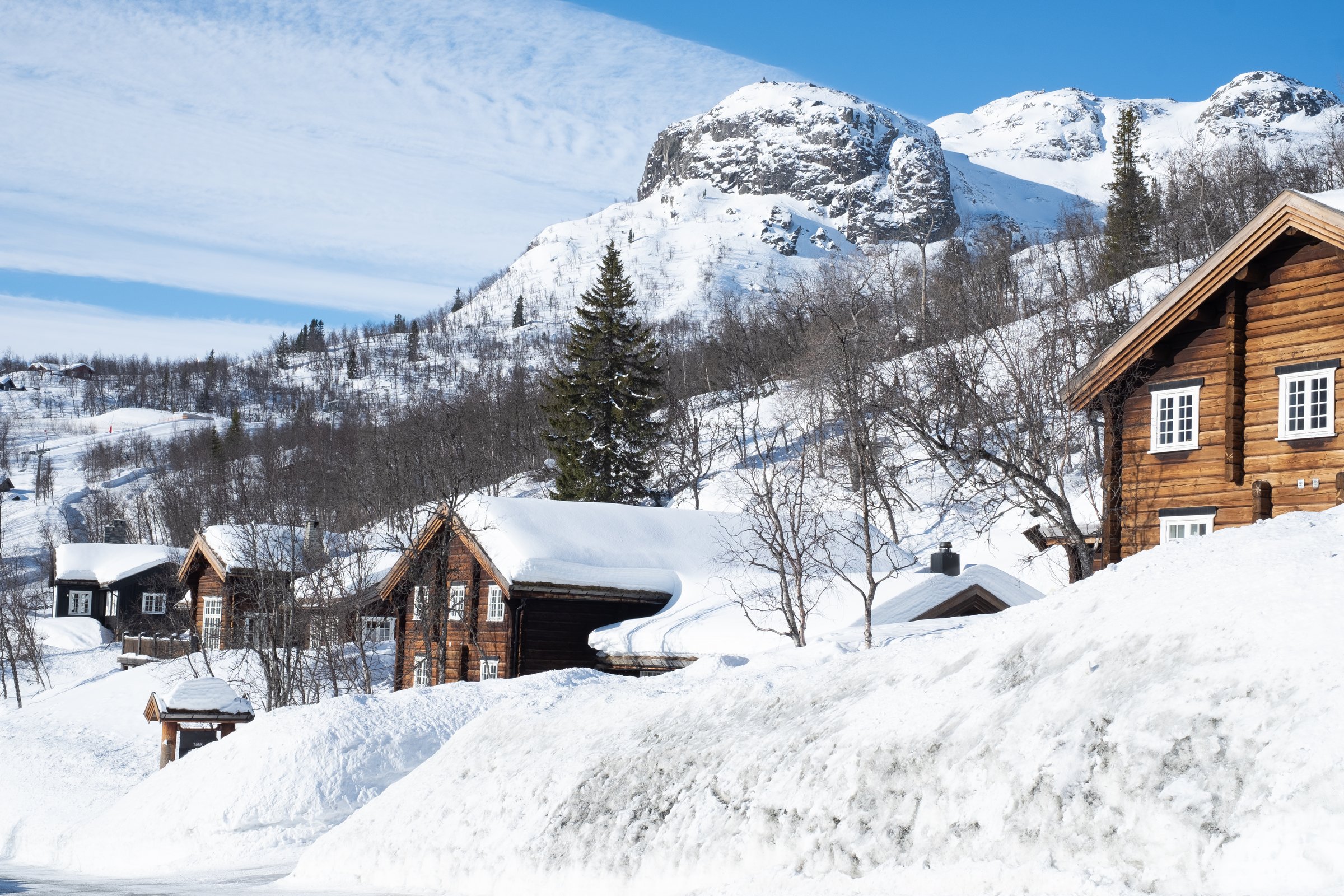 Cozy wooden cabin under snow in the mountains during winter.