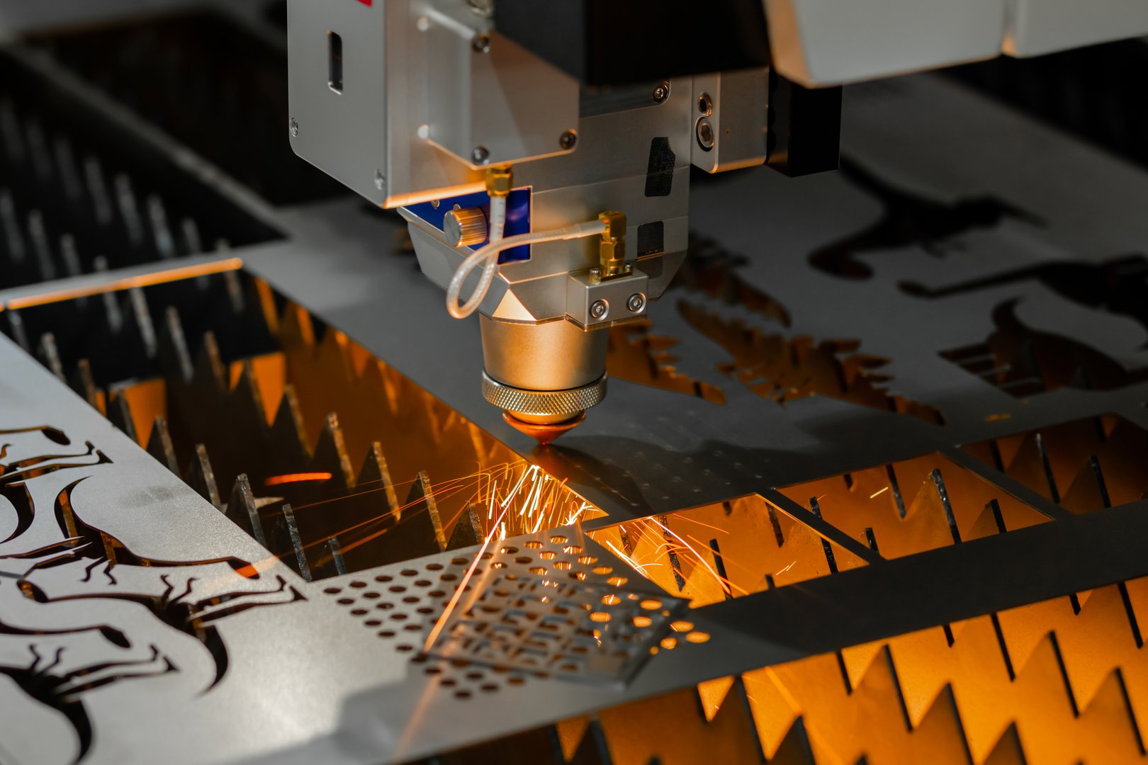 Automatic cnc laser cutting machine working with sheet metal with many sparks at factory, plant. Metalworking, industrial, manufacturing, technology and equipment concept