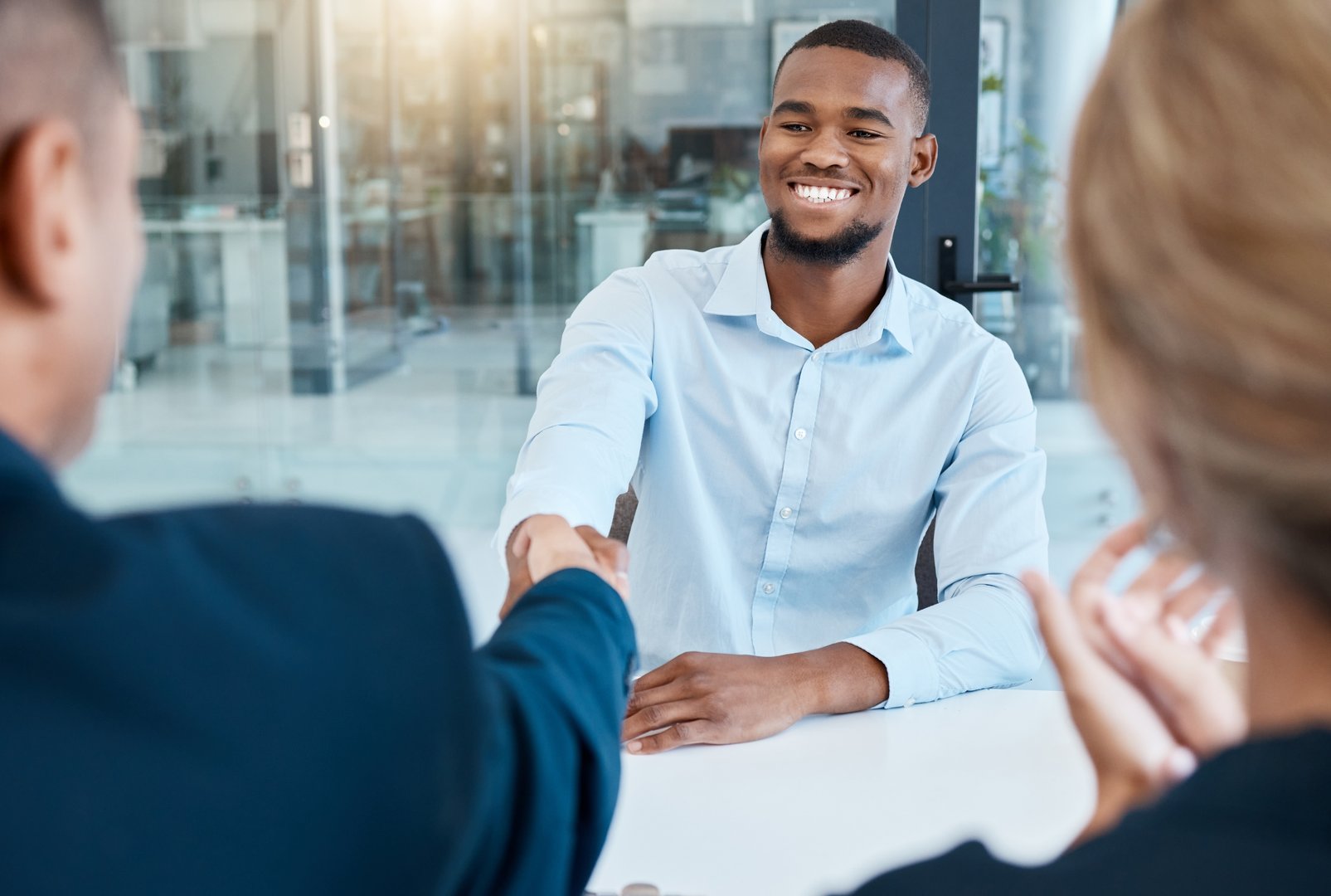 Shaking hands, interview and business people give a handshake after hiring a new company employee