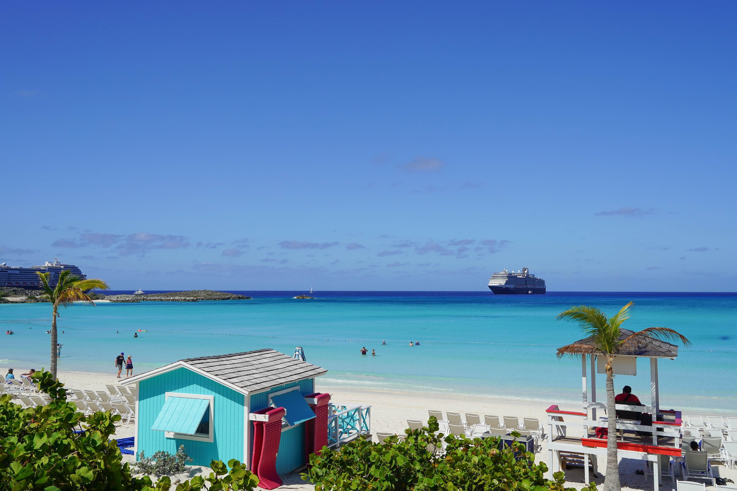 The Bahamas -- April 5, 2025: A luxury cruise ship on the horizon. A lifeguard watches over tourists swimming in a cay in The Bahamas.