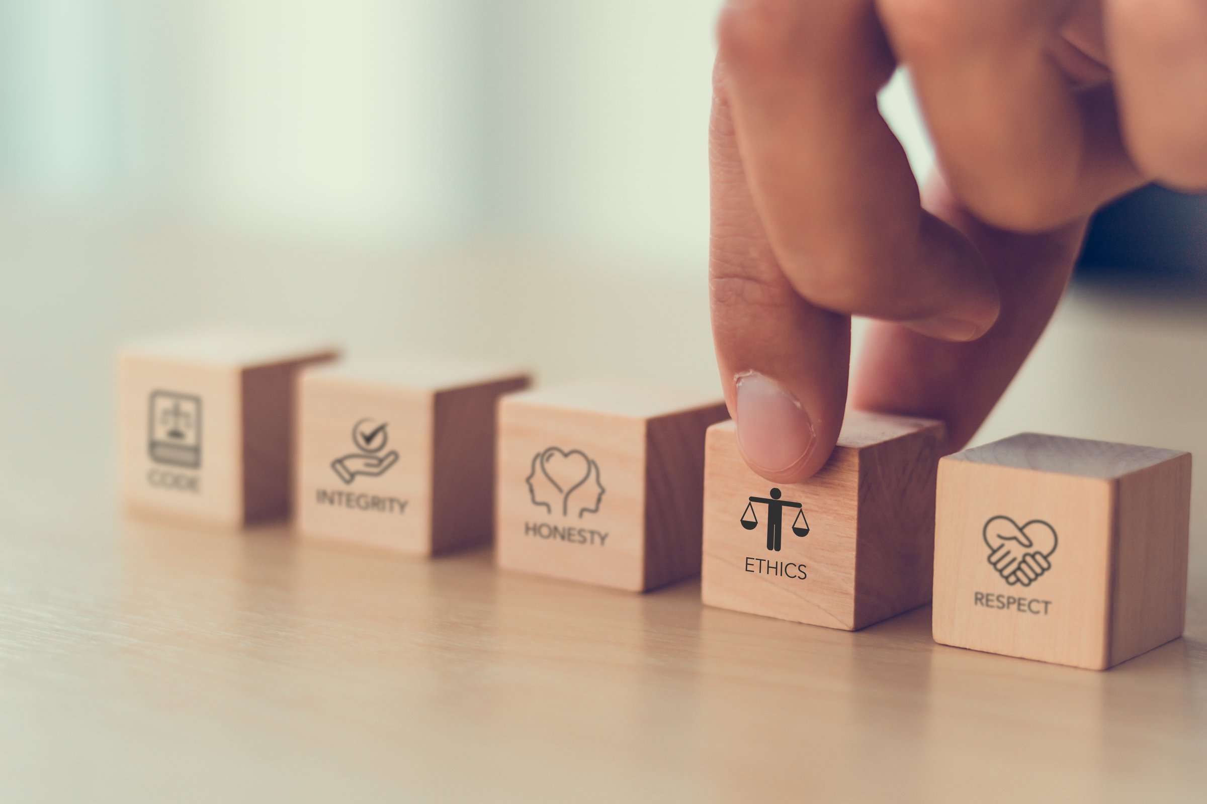 Code of conduct in business concept. Wooden blocks with code of conduct icons; code, integrity, honesty, respect, and ethics,  the foundation of a strong corporate code of conduct. Corporate ethics.