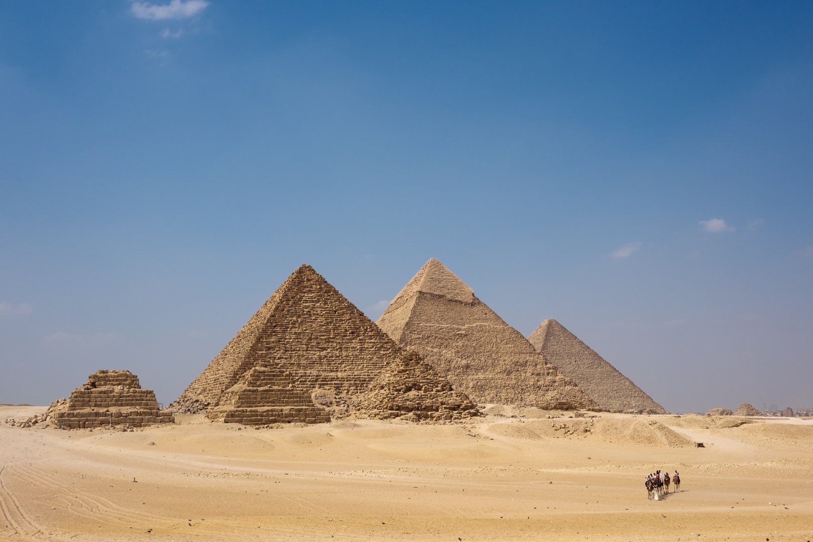 The Pyramids of Giza stand majestically in the sandy landscape of Egypt, showcasing ancient architecture. These iconic structures are a testament to the engineering prowess of the ancient Egyptians and attract countless visitors.
