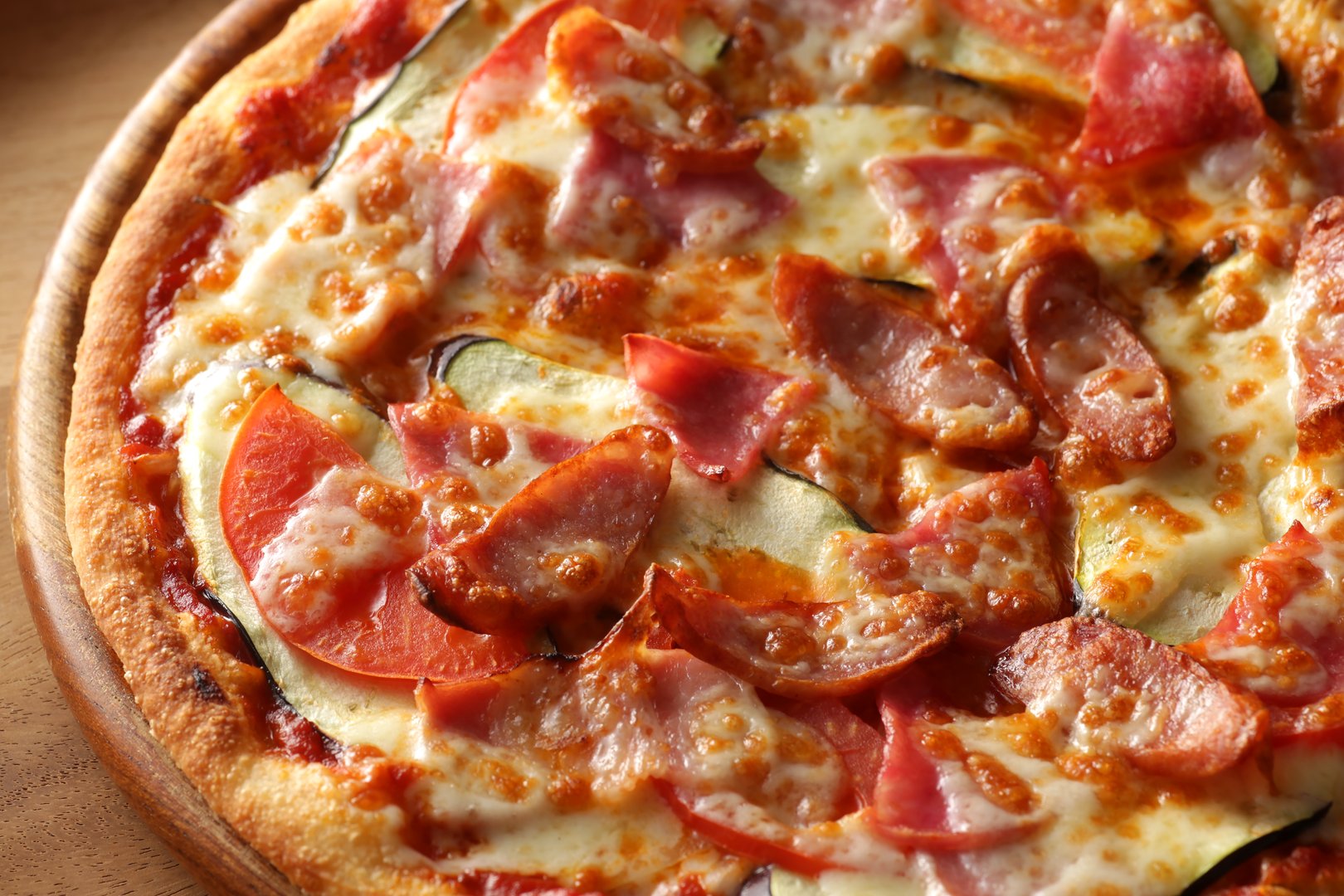 Pizza with cold cuts including salami, ham, sausage, and leg of ham