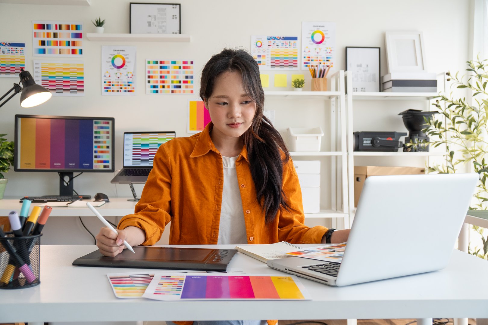 Female designer creating digital designs in a bright studio.
