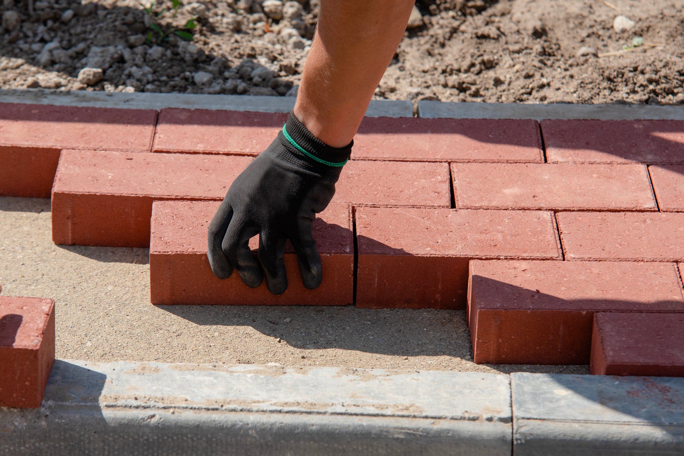 Worker laying paving bricks
