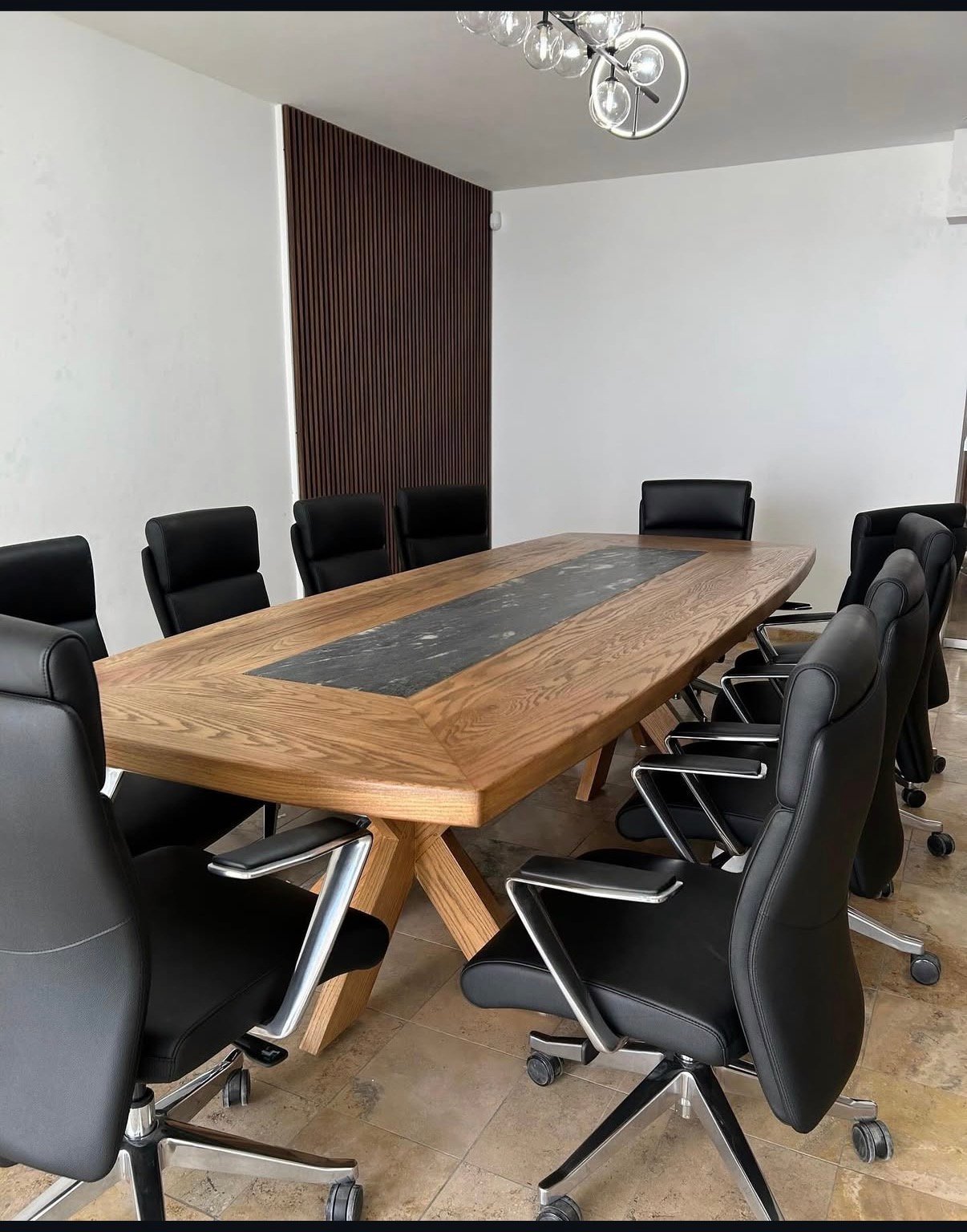 Mesa de conferencia para 10-12 personas fabricada en madera sólida con inserto central de granito negro y base en X