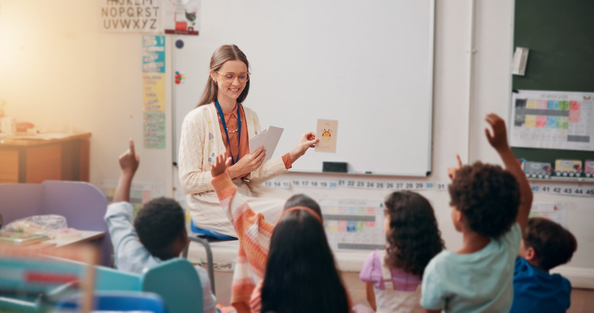 Teacher, children and flash cards with answer in lesson for animal questions, alphabet knowledge or feedback. Educator, people and students with hands raised for creative development or language quiz