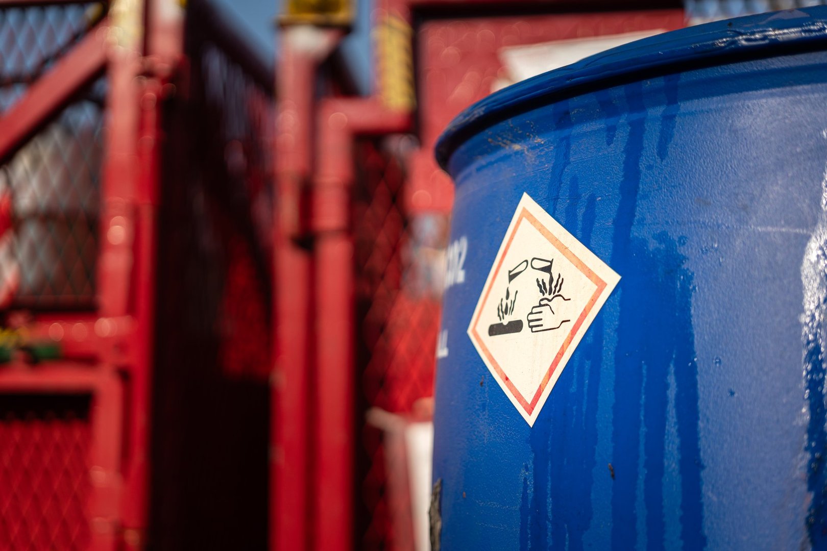 Acidity corrosion or skin burn hazard, safety sign on the chemical containment barrel. Sign and symbol for industrial product, close-up.