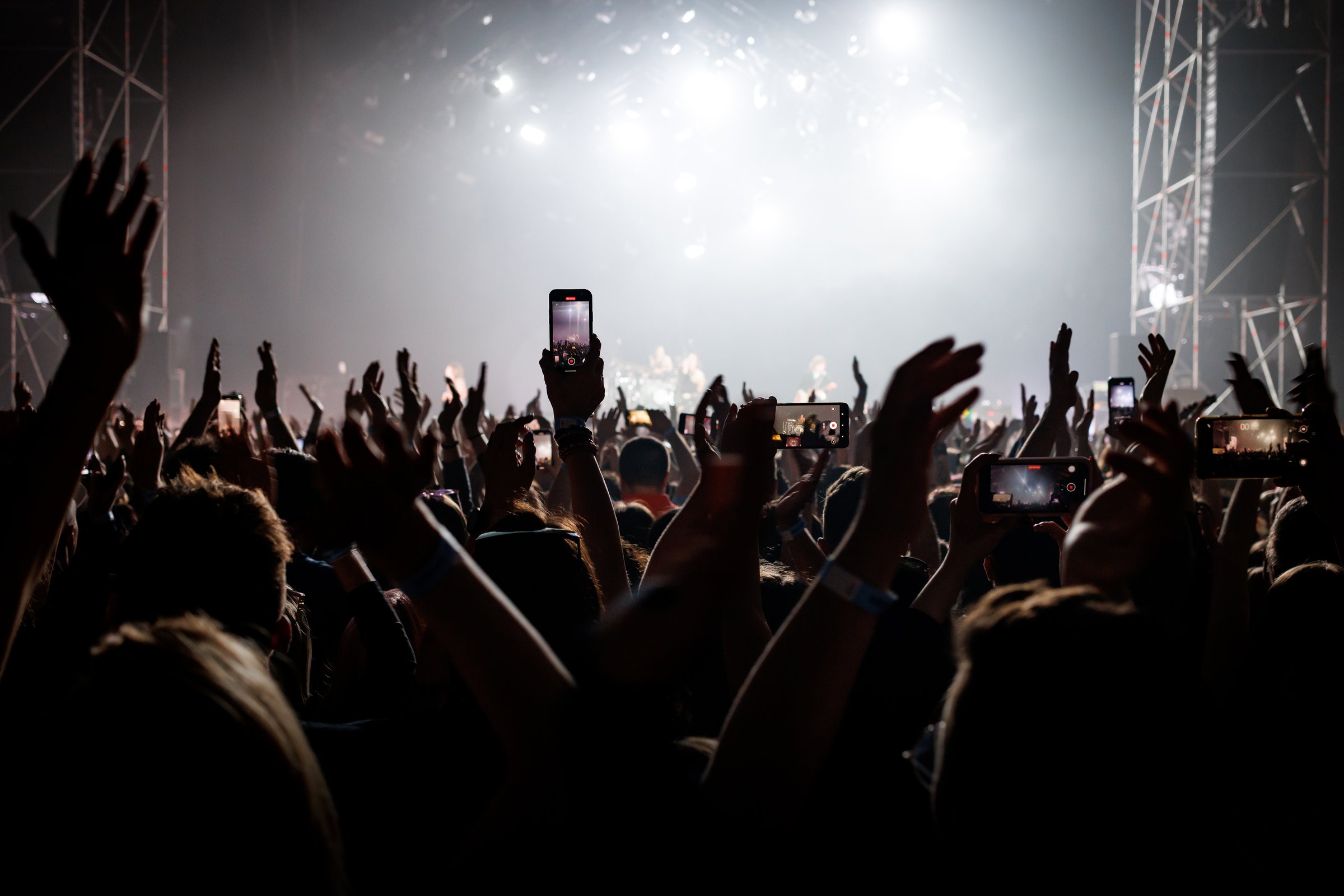 Audience with raised hands on a dance floor at a music festival