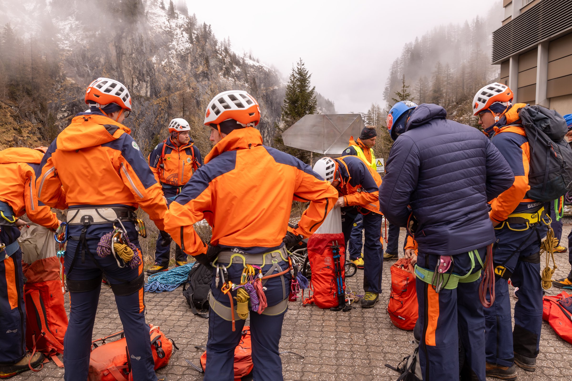 Austria, Gasteinertal - April 26, 2025: Mountain rescue team prepares for a training exercise in the Alps during cloudy weather with heavy gear and ropes
